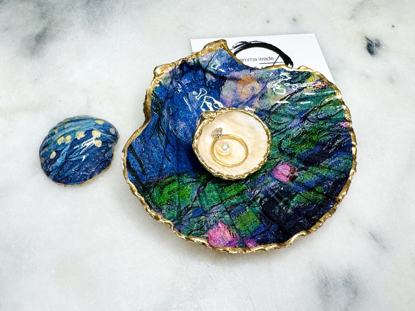 Claude Monet Waterlilies inspired shell dish set featuring a scallop trinket dish and cockle ring holder | Decorated with blue and pink floral waterlilies | Gilded with real gold leaf and sealed in high gloss resin | Perfect as a wedding ring tray, jewellery dish, or vanity display | Handmade in Dorset from sustainably sourced shells | A coastal art-inspired gift for weddings, birthdays, or anniversaries