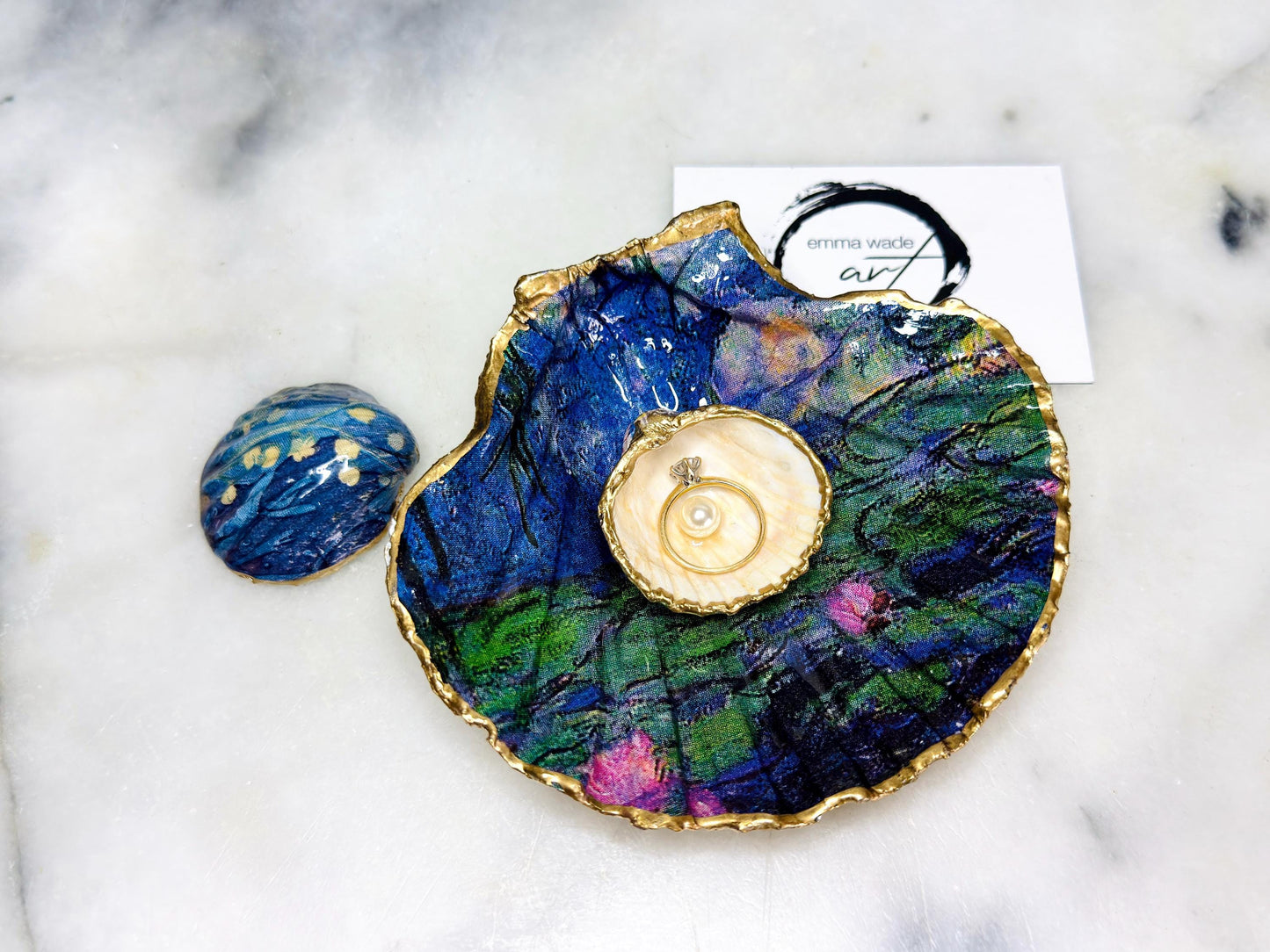 Claude Monet Waterlilies inspired shell dish set featuring a scallop trinket dish and cockle ring holder | Decorated with blue and pink floral waterlilies | Gilded with real gold leaf and sealed in high gloss resin | Perfect as a wedding ring tray, jewellery dish, or vanity display | Handmade in Dorset from sustainably sourced shells | A coastal art-inspired gift for weddings, birthdays, or anniversaries