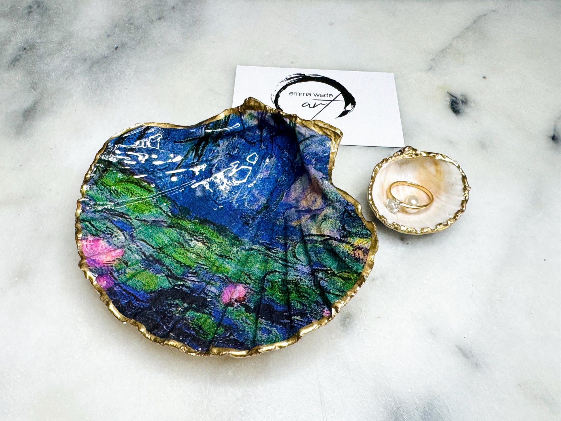Claude Monet Waterlilies inspired shell dish set featuring a scallop trinket dish and cockle ring holder | Decorated with blue and pink floral waterlilies | Gilded with real gold leaf and sealed in high gloss resin | Perfect as a wedding ring tray, jewellery dish, or vanity display | Handmade in Dorset from sustainably sourced shells | A coastal art-inspired gift for weddings, birthdays, or anniversaries