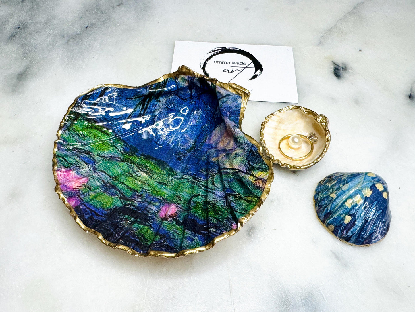 Claude Monet Waterlilies inspired shell dish set featuring a scallop trinket dish and cockle ring holder | Decorated with blue and pink floral waterlilies | Gilded with real gold leaf and sealed in high gloss resin | Perfect as a wedding ring tray, jewellery dish, or vanity display | Handmade in Dorset from sustainably sourced shells | A coastal art-inspired gift for weddings, birthdays, or anniversaries