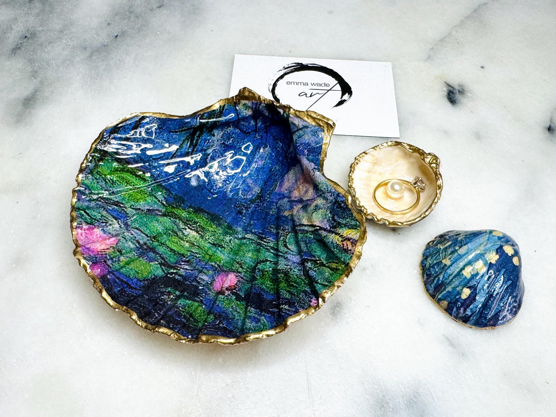 Claude Monet Waterlilies inspired shell dish set featuring a scallop trinket dish and cockle ring holder | Decorated with blue and pink floral waterlilies | Gilded with real gold leaf and sealed in high gloss resin | Perfect as a wedding ring tray, jewellery dish, or vanity display | Handmade in Dorset from sustainably sourced shells | A coastal art-inspired gift for weddings, birthdays, or anniversaries