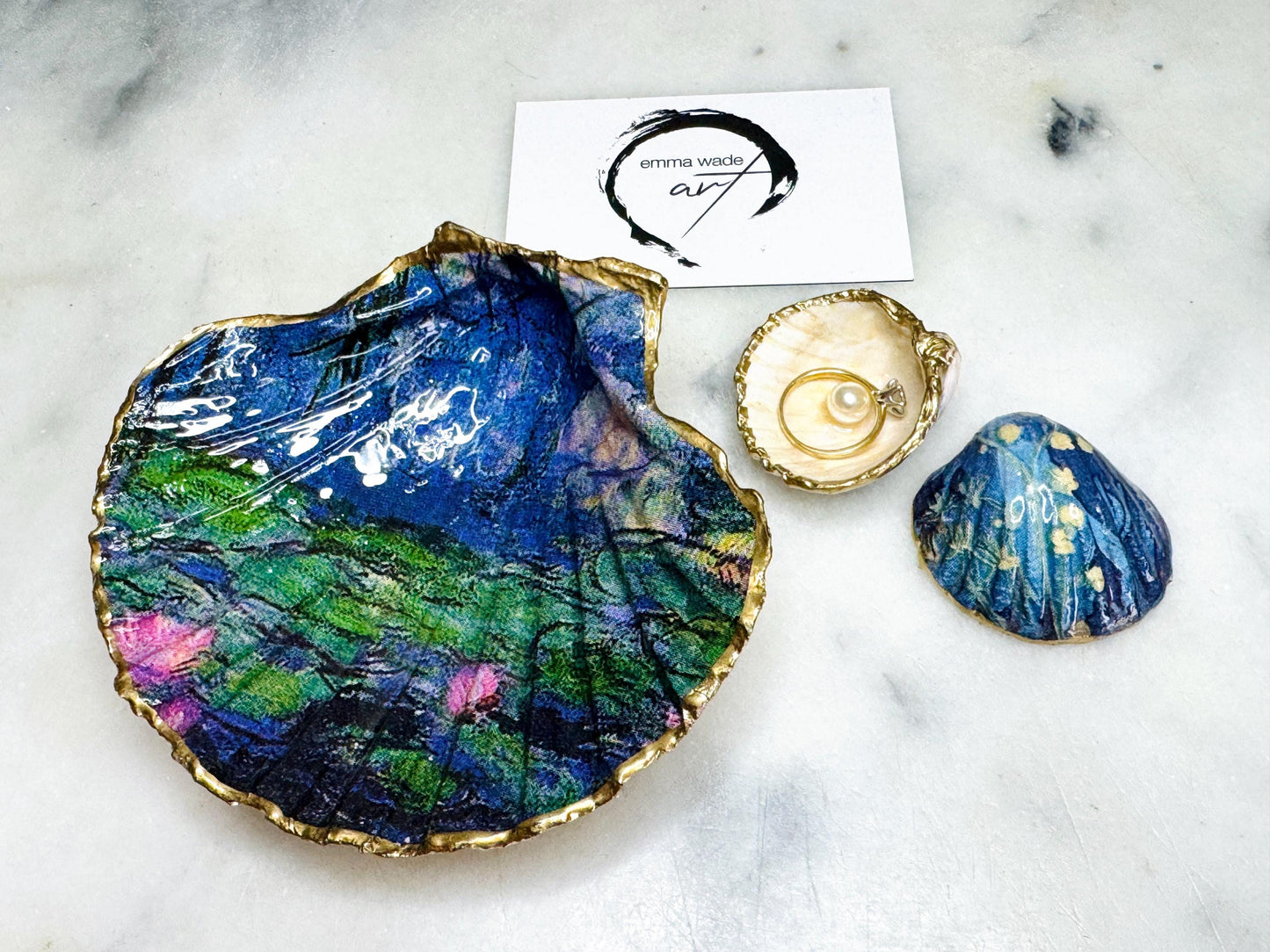 Claude Monet Waterlilies inspired shell dish set featuring a scallop trinket dish and cockle ring holder | Decorated with blue and pink floral waterlilies | Gilded with real gold leaf and sealed in high gloss resin | Perfect as a wedding ring tray, jewellery dish, or vanity display | Handmade in Dorset from sustainably sourced shells | A coastal art-inspired gift for weddings, birthdays, or anniversaries