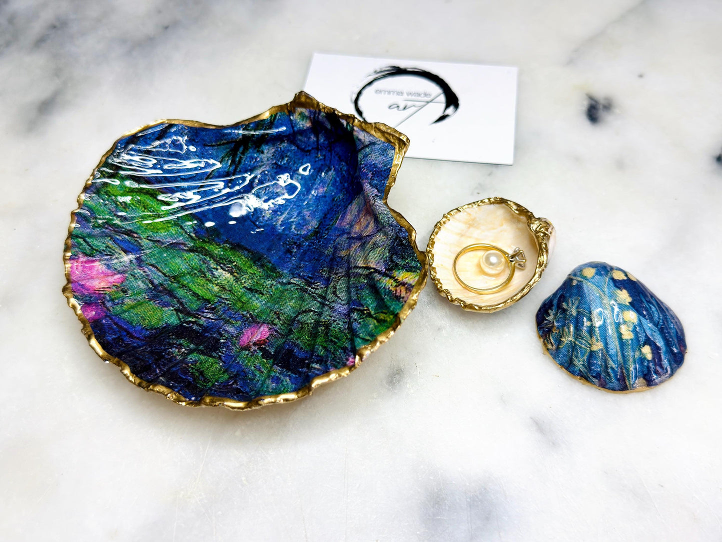 Claude Monet Waterlilies inspired shell dish set featuring a scallop trinket dish and cockle ring holder | Decorated with blue and pink floral waterlilies | Gilded with real gold leaf and sealed in high gloss resin | Perfect as a wedding ring tray, jewellery dish, or vanity display | Handmade in Dorset from sustainably sourced shells | A coastal art-inspired gift for weddings, birthdays, or anniversaries