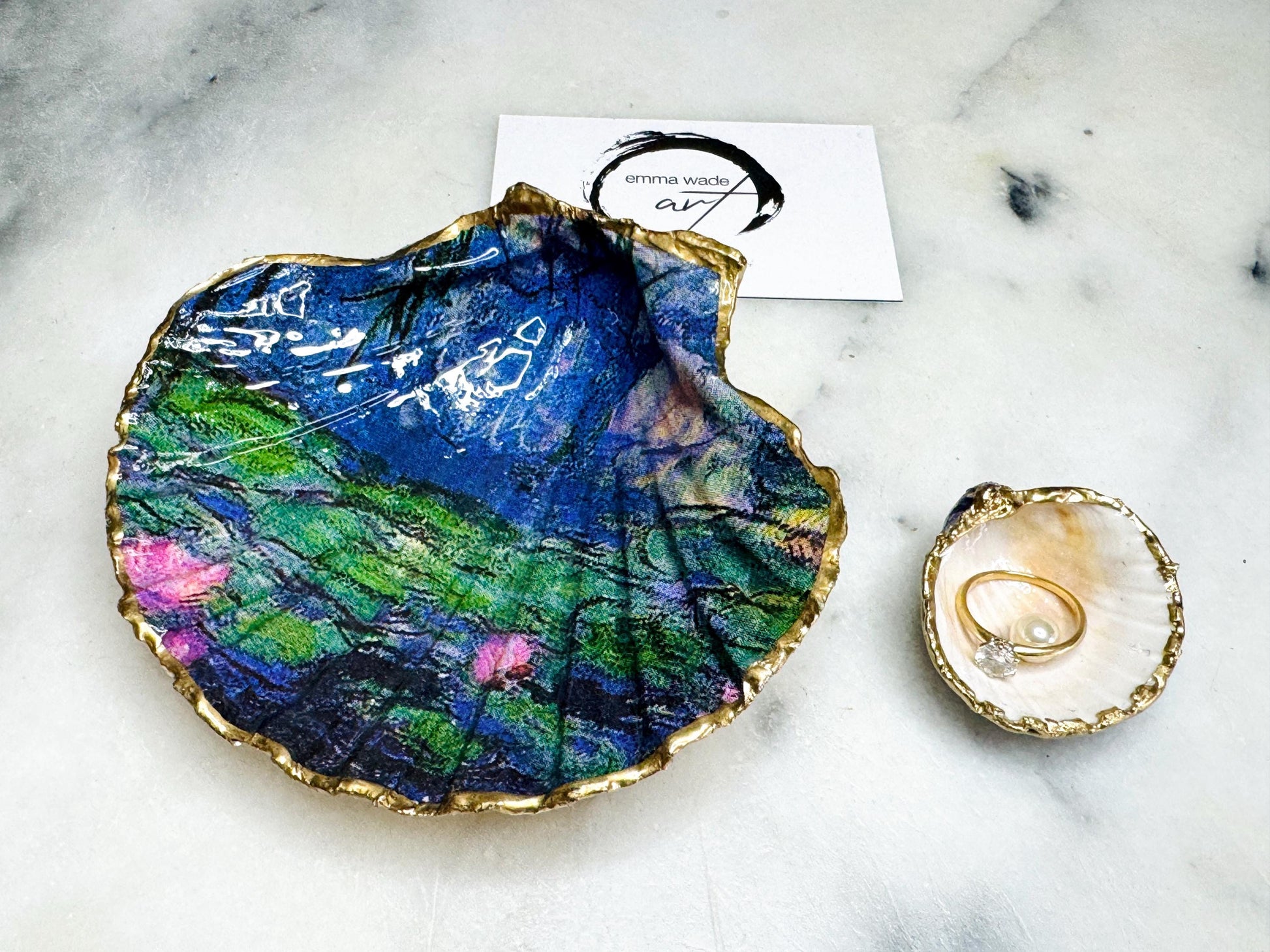 Claude Monet Waterlilies inspired shell dish set featuring a scallop trinket dish and cockle ring holder | Decorated with blue and pink floral waterlilies | Gilded with real gold leaf and sealed in high gloss resin | Perfect as a wedding ring tray, jewellery dish, or vanity display | Handmade in Dorset from sustainably sourced shells | A coastal art-inspired gift for weddings, birthdays, or anniversaries