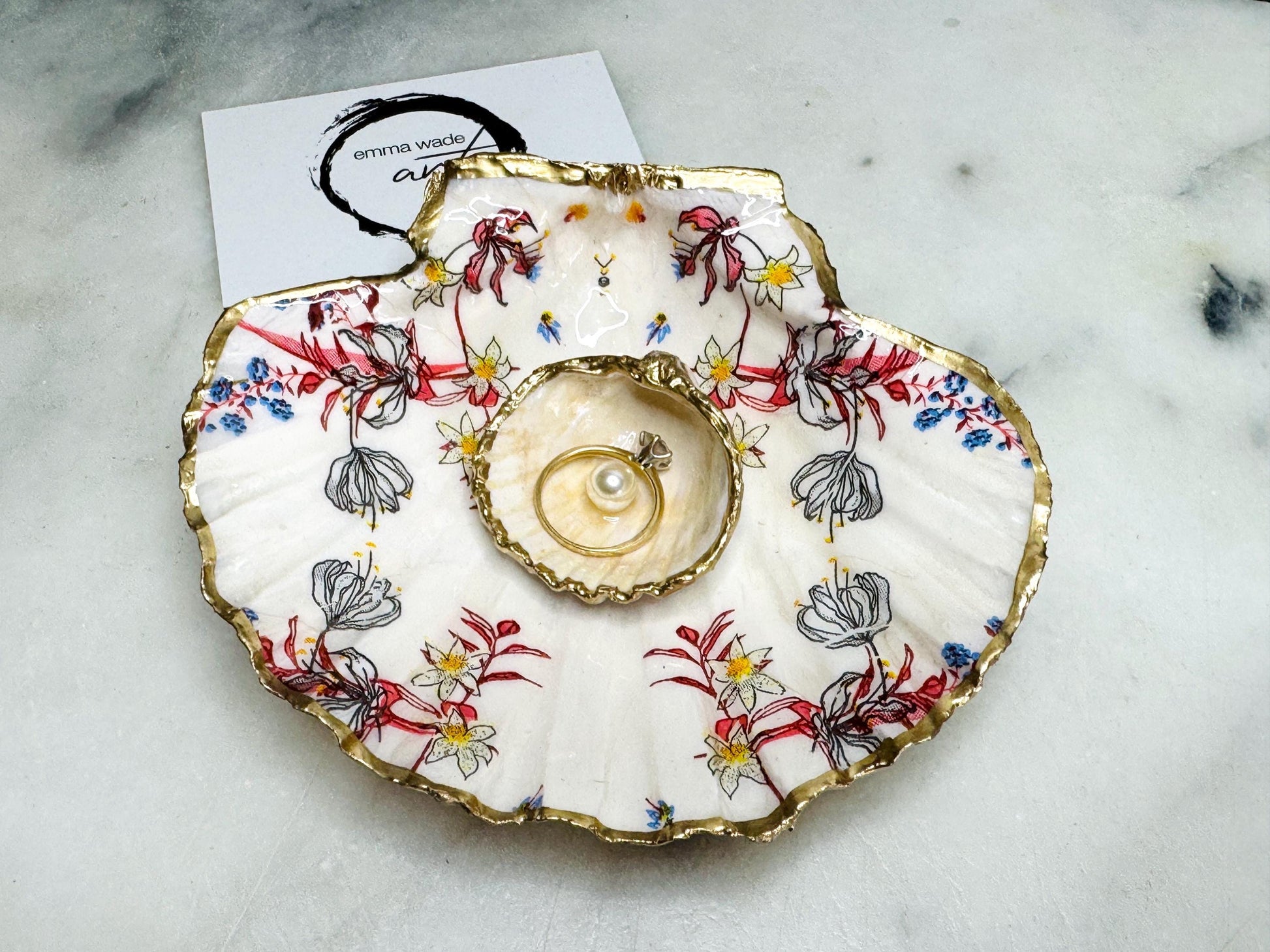Handcrafted Dorset shell dish set featuring red and blue floral designs on scallop and cockle shells | Cockle shell includes a Swarovski pearl ring rest to prevent rings from sliding | Gilded with liquid gold leaf and sealed with glossy resin | Perfect as a jewellery or ring holder, trinket tray, or coastal gift | Each shell is sustainably sourced and hand finished in the UK | Ideal wedding or anniversary keepsake