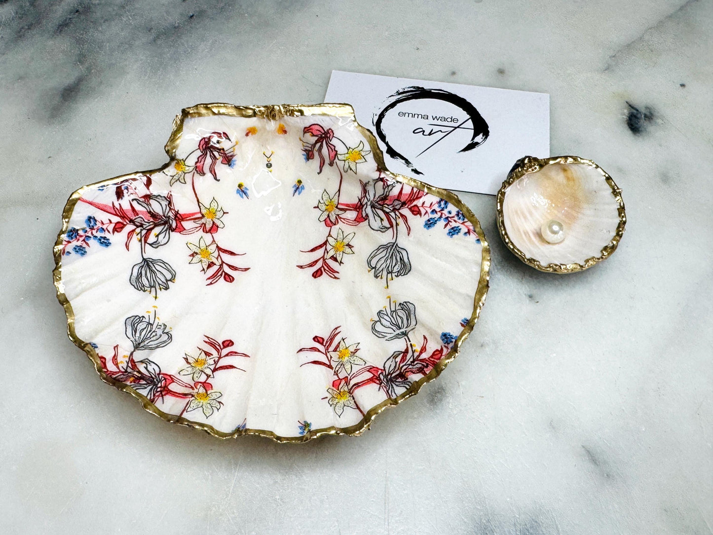 Handcrafted Dorset shell dish set featuring red and blue floral designs on scallop and cockle shells | Cockle shell includes a Swarovski pearl ring rest to prevent rings from sliding | Gilded with liquid gold leaf and sealed with glossy resin | Perfect as a jewellery or ring holder, trinket tray, or coastal gift | Each shell is sustainably sourced and hand finished in the UK | Ideal wedding or anniversary keepsake
