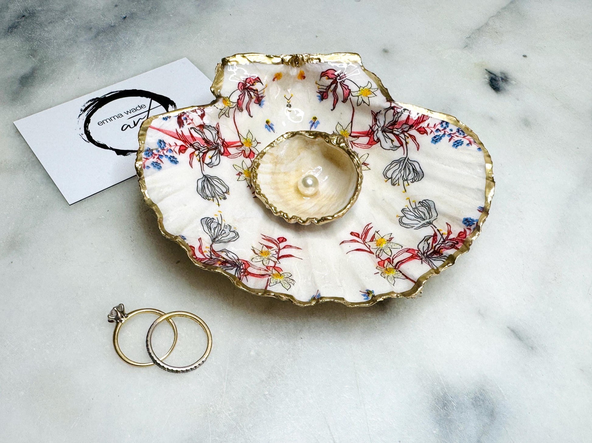 Handcrafted Dorset shell dish set featuring red and blue floral designs on scallop and cockle shells | Cockle shell includes a Swarovski pearl ring rest to prevent rings from sliding | Gilded with liquid gold leaf and sealed with glossy resin | Perfect as a jewellery or ring holder, trinket tray, or coastal gift | Each shell is sustainably sourced and hand finished in the UK | Ideal wedding or anniversary keepsake