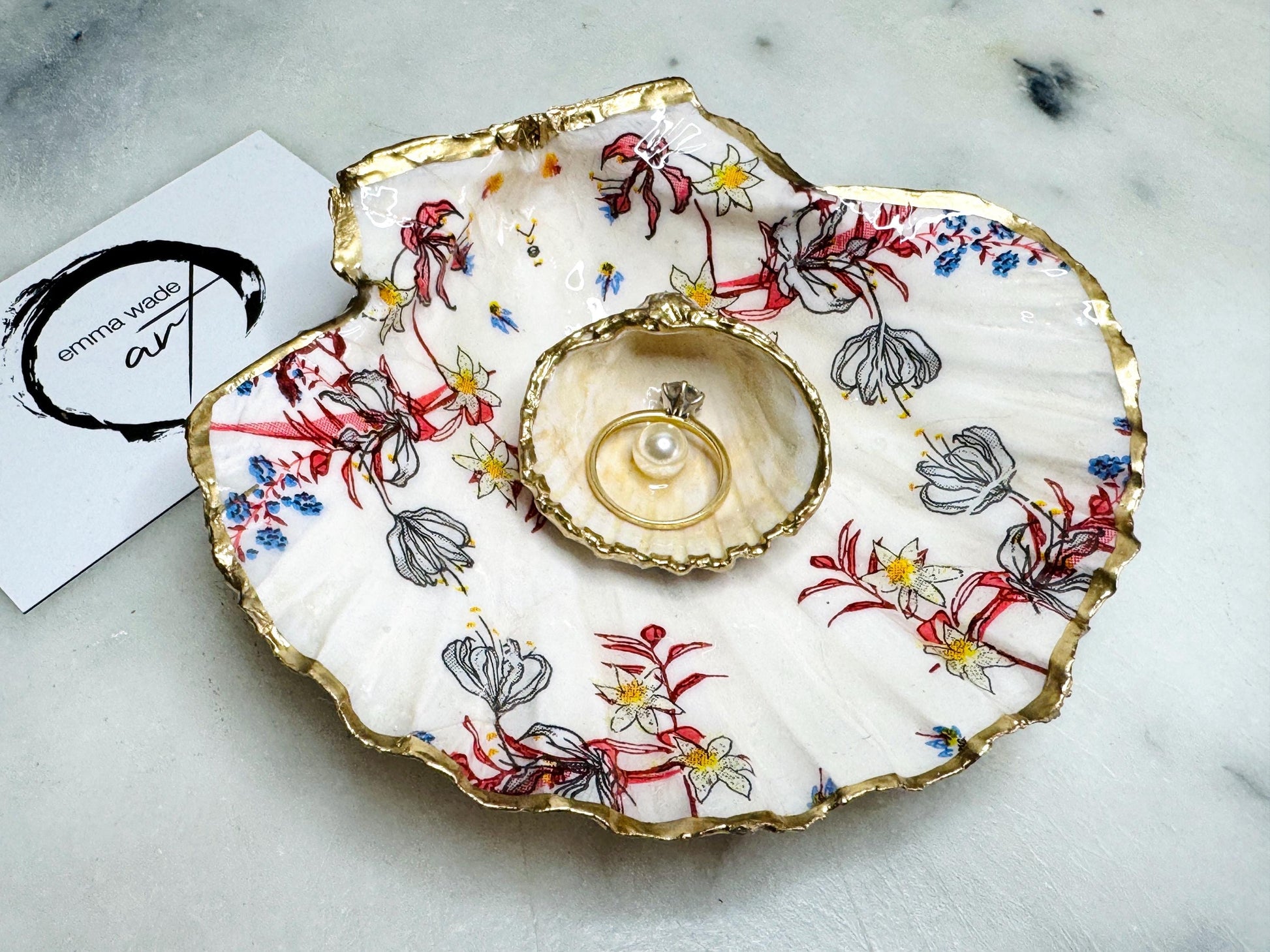 Handcrafted Dorset shell dish set featuring red and blue floral designs on scallop and cockle shells | Cockle shell includes a Swarovski pearl ring rest to prevent rings from sliding | Gilded with liquid gold leaf and sealed with glossy resin | Perfect as a jewellery or ring holder, trinket tray, or coastal gift | Each shell is sustainably sourced and hand finished in the UK | Ideal wedding or anniversary keepsake