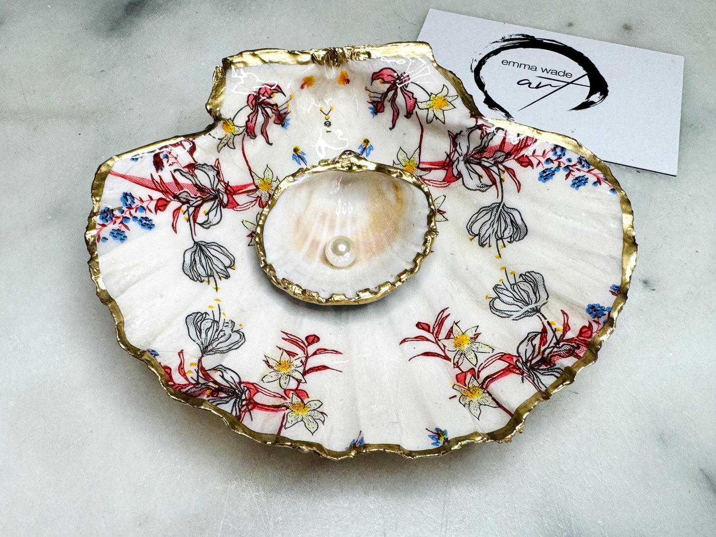 Handcrafted Dorset shell dish set featuring red and blue floral designs on scallop and cockle shells | Cockle shell includes a Swarovski pearl ring rest to prevent rings from sliding | Gilded with liquid gold leaf and sealed with glossy resin | Perfect as a jewellery or ring holder, trinket tray, or coastal gift | Each shell is sustainably sourced and hand finished in the UK | Ideal wedding or anniversary keepsake