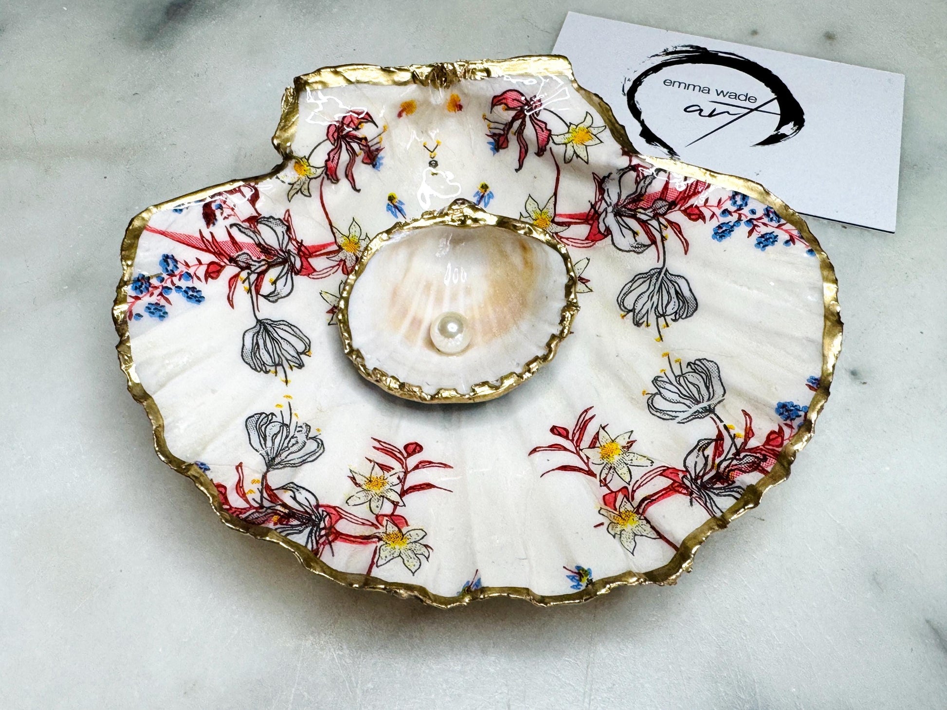 Handcrafted Dorset shell dish set featuring red and blue floral designs on scallop and cockle shells | Cockle shell includes a Swarovski pearl ring rest to prevent rings from sliding | Gilded with liquid gold leaf and sealed with glossy resin | Perfect as a jewellery or ring holder, trinket tray, or coastal gift | Each shell is sustainably sourced and hand finished in the UK | Ideal wedding or anniversary keepsake