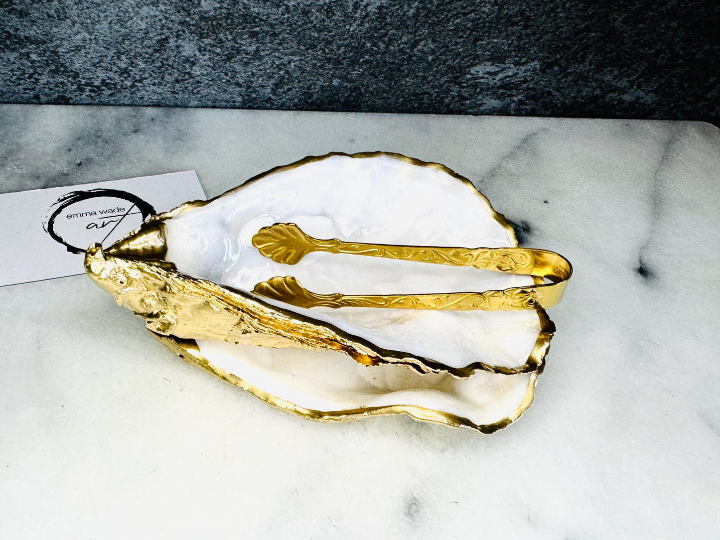 Extra large Dorset oyster shell serving dish set with natural pearl interior and hand-applied gold leaf edging, featuring a cupped XL oyster shell with matching flat shell base. Luxury coastal home décor ideal as a sugar dish, serving bowl, coffee station accessory, or elegant host gift. Handmade using sustainably sourced UK oyster shells and finished with glossy resin and optional gold serving accessories.