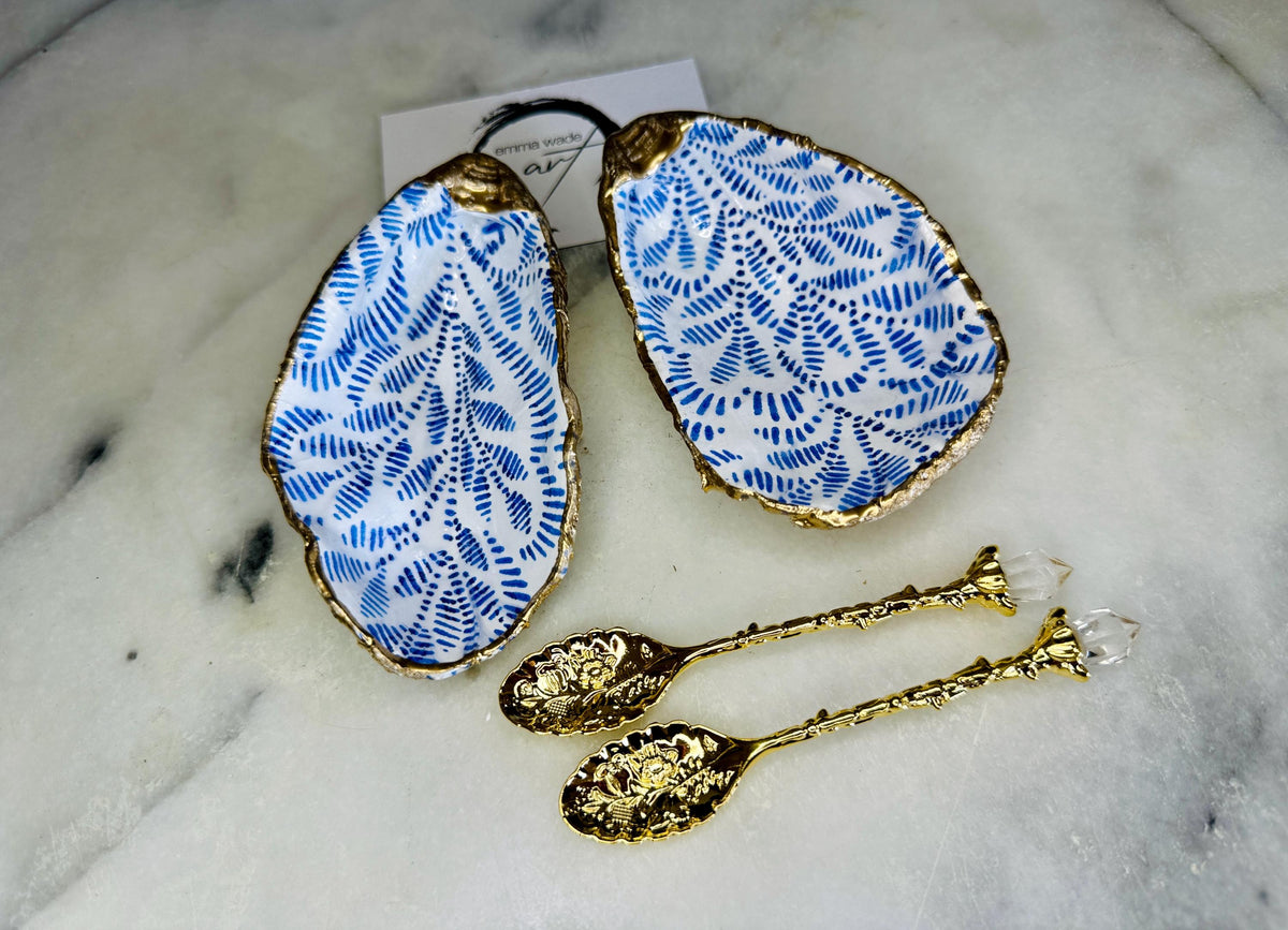 Sustainable Dorset oyster shell cruet set featuring blue floral designs and real gold leaf edges | Handmade salt and pepper pinch pots, sealed with food-safe glossy resin and presented in a sustainable kraft gift box | A unique salt gift for weddings, anniversaries, and coastal dining | Includes optional gold crystal spoons | Perfect handmade gift for beach house decor or ocean-inspired table styling | Maimekko Design