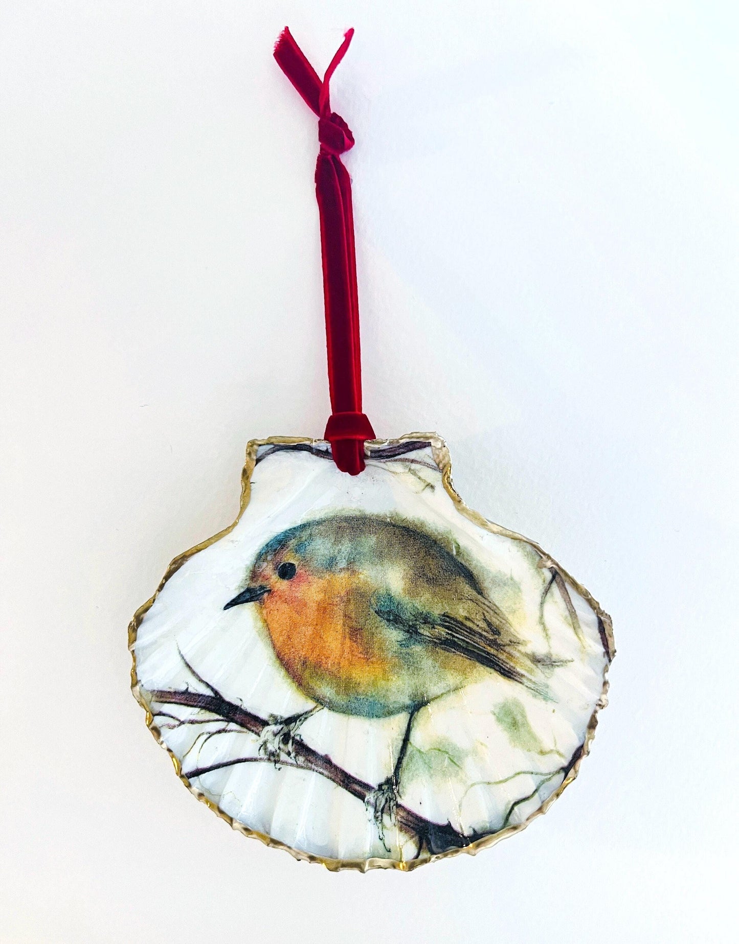 Handcrafted Dorset scallop shell trinket dish featuring a robin redbreast illustration with gold leaf edging and glossy resin finish. Coastal cottagecore jewellery holder and Christmas hanging ornament with natural shell texture and festive British bird design.
