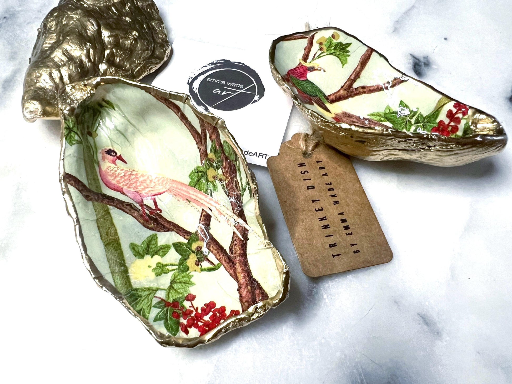 Handmade oyster shell trinket dish featuring colourful Bird of Paradise artwork with gold leaf edging and glossy resin finish. Tropical coastal jewellery dish crafted from natural Dorset shells, styled as a ring holder, keepsake tray, or exotic nature-inspired gift.