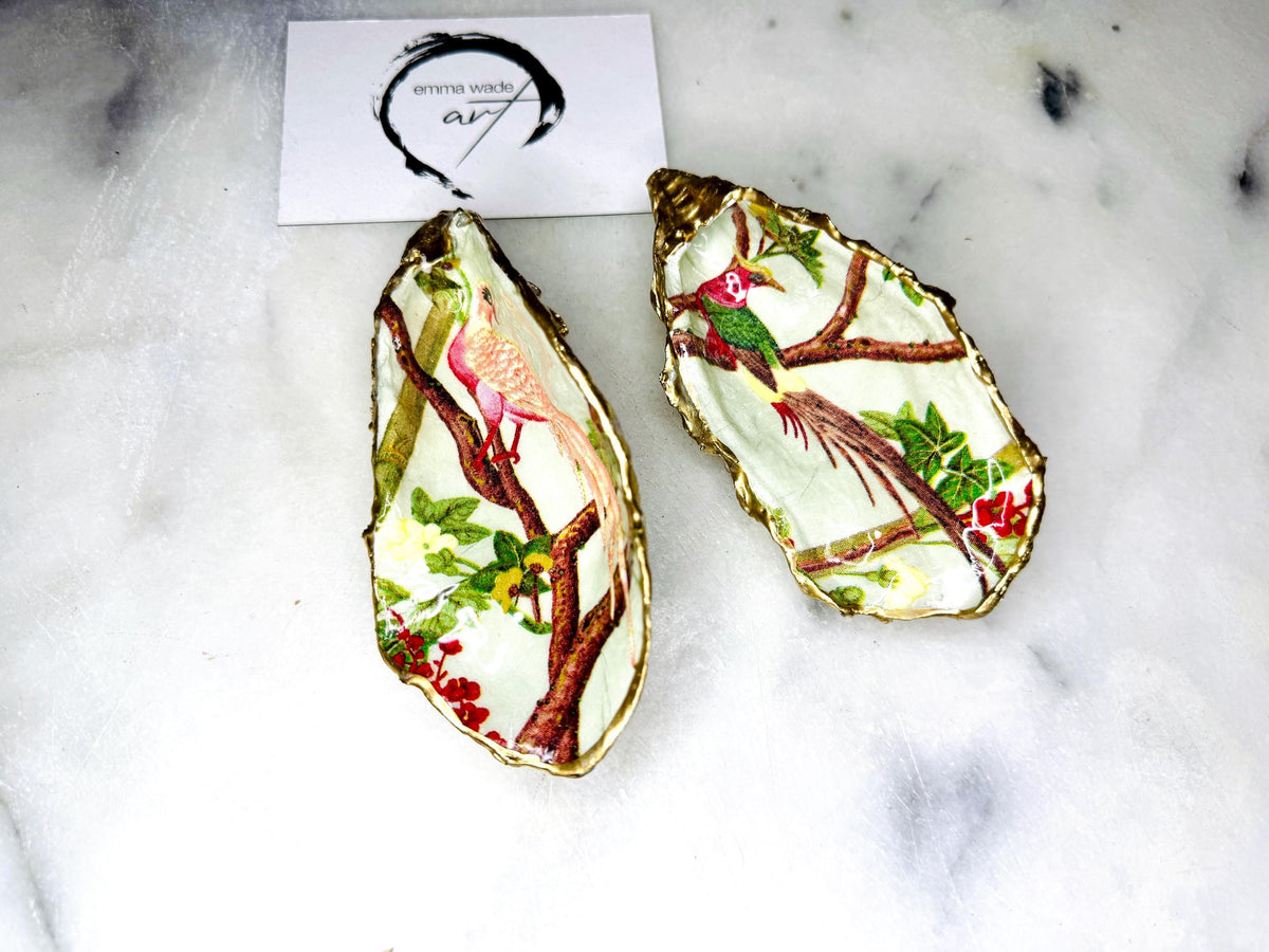 Handmade oyster shell trinket dish featuring colourful Bird of Paradise artwork with gold leaf edging and glossy resin finish. Tropical coastal jewellery dish crafted from natural Dorset shells, styled as a ring holder, keepsake tray, or exotic nature-inspired gift.