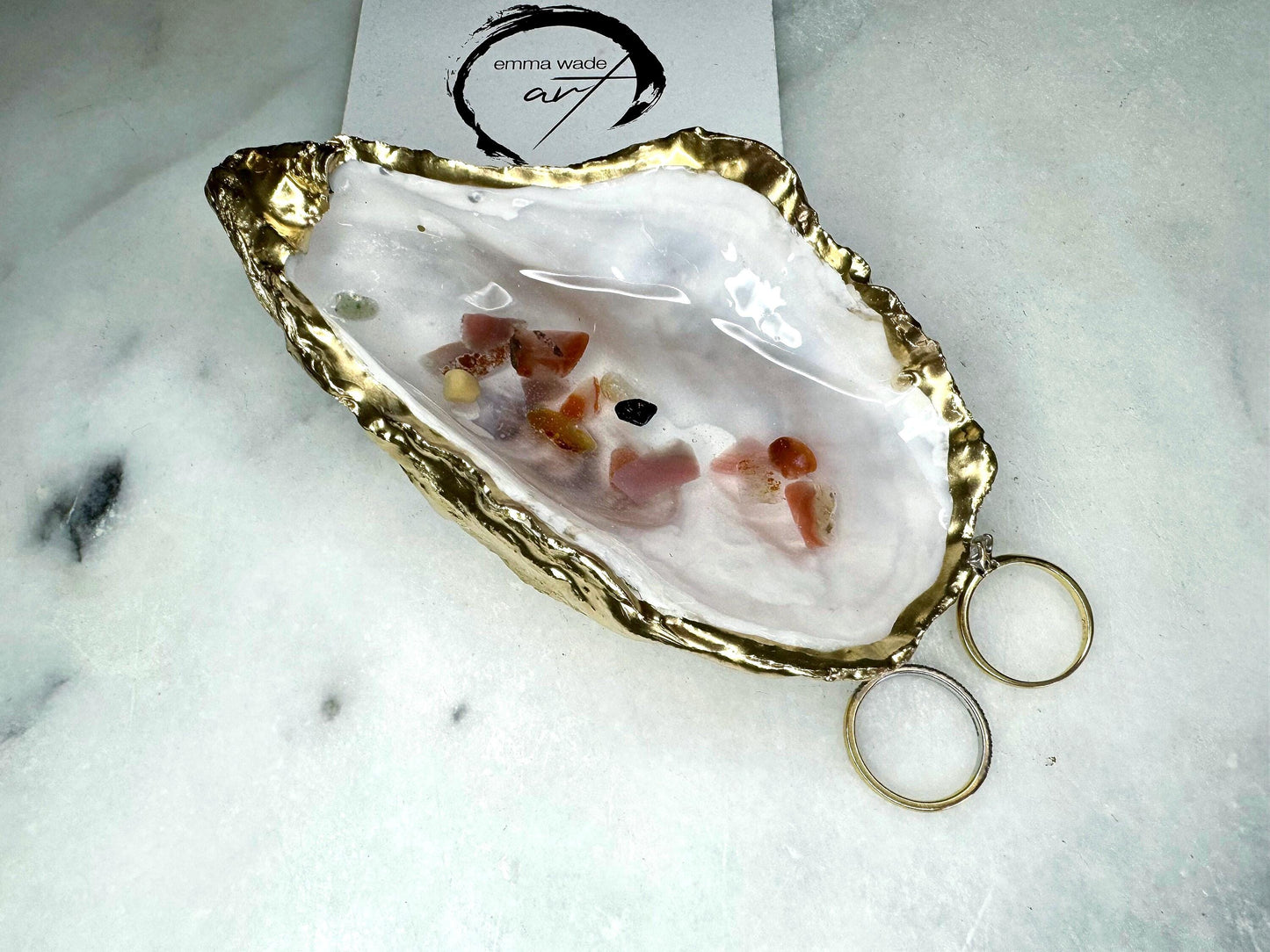 Handmade oyster shell jewellery dish with real Dorset sea glass foraged from the coast and suspended in clear glossy resin to look like a rock pool. Finished with gold leaf trim and a natural pearl interior, this unique shell dish can be used as a ring holder, jewellery tray, or trinket catcher for earrings, cufflinks, or keepsakes. A one-of-a-kind coastal-inspired gift for weddings, anniversaries, birthdays, bridesmaids, Christmas, or Mother’s Day.