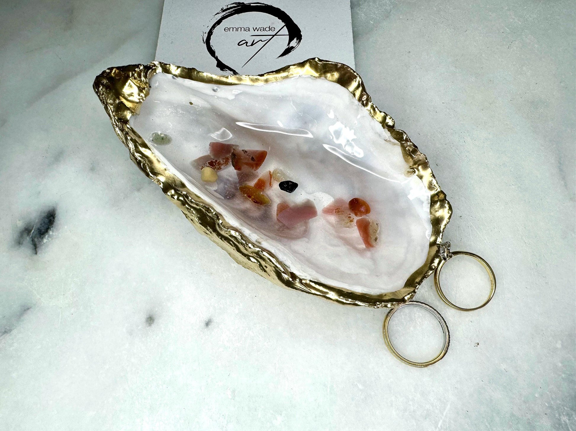 Handmade oyster shell jewellery dish with real Dorset sea glass foraged from the coast and suspended in clear glossy resin to look like a rock pool. Finished with gold leaf trim and a natural pearl interior, this unique shell dish can be used as a ring holder, jewellery tray, or trinket catcher for earrings, cufflinks, or keepsakes. A one-of-a-kind coastal-inspired gift for weddings, anniversaries, birthdays, bridesmaids, Christmas, or Mother’s Day.