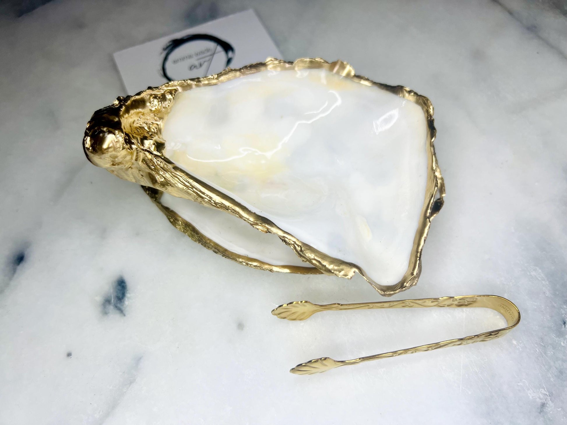 Extra large Dorset oyster shell serving dish set with natural pearl interior and hand-applied gold leaf edging, featuring a cupped XL oyster shell with matching flat shell base. Luxury coastal home décor ideal as a sugar dish, serving bowl, coffee station accessory, or elegant host gift. Handmade using sustainably sourced UK oyster shells and finished with glossy resin and optional gold serving accessories.