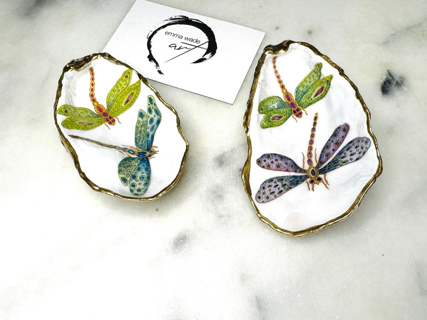 Handmade dragonfly oyster shell trinket dish with hand-gilded gold leaf edges and glossy resin finish, created from sustainably sourced Dorset shells. Unique coastal jewellery holder and ring dish, ideal as a vanity tray, trinket tray or decorative keepsake. Nature inspired home decor gift for birthdays, weddings, anniversaries, housewarmings and Mother’s Day. One of a kind artisan shell dish, beautifully presented in a gift box.