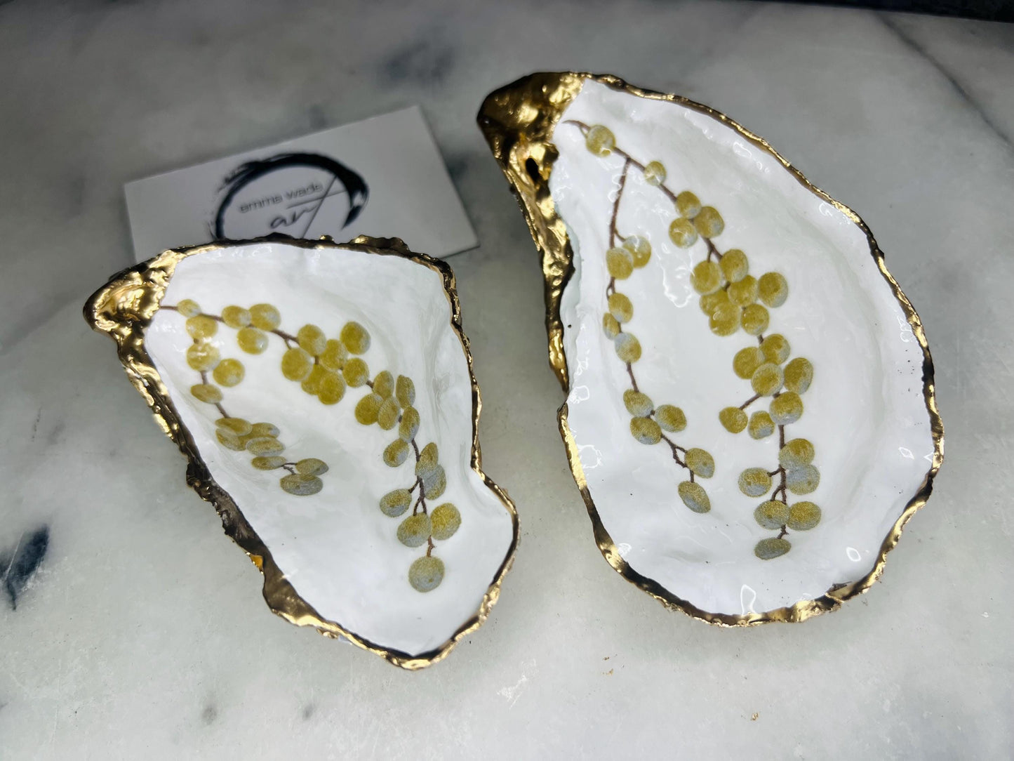 Handmade Dorset oyster shell dish with a gold and white berries design, gilded with liquid gold leaf on the rim and back, and sealed in crystal-clear resin for a glossy shine. Each oyster shell jewellery dish is unique, perfect as a ring holder, trinket tray, or organiser for earrings, cufflinks, and small keepsakes. A meaningful handmade oyster ring dish for weddings, anniversaries, birthdays, bridesmaids, or festive celebrations. Ideal as UK coastal-inspired home décor.