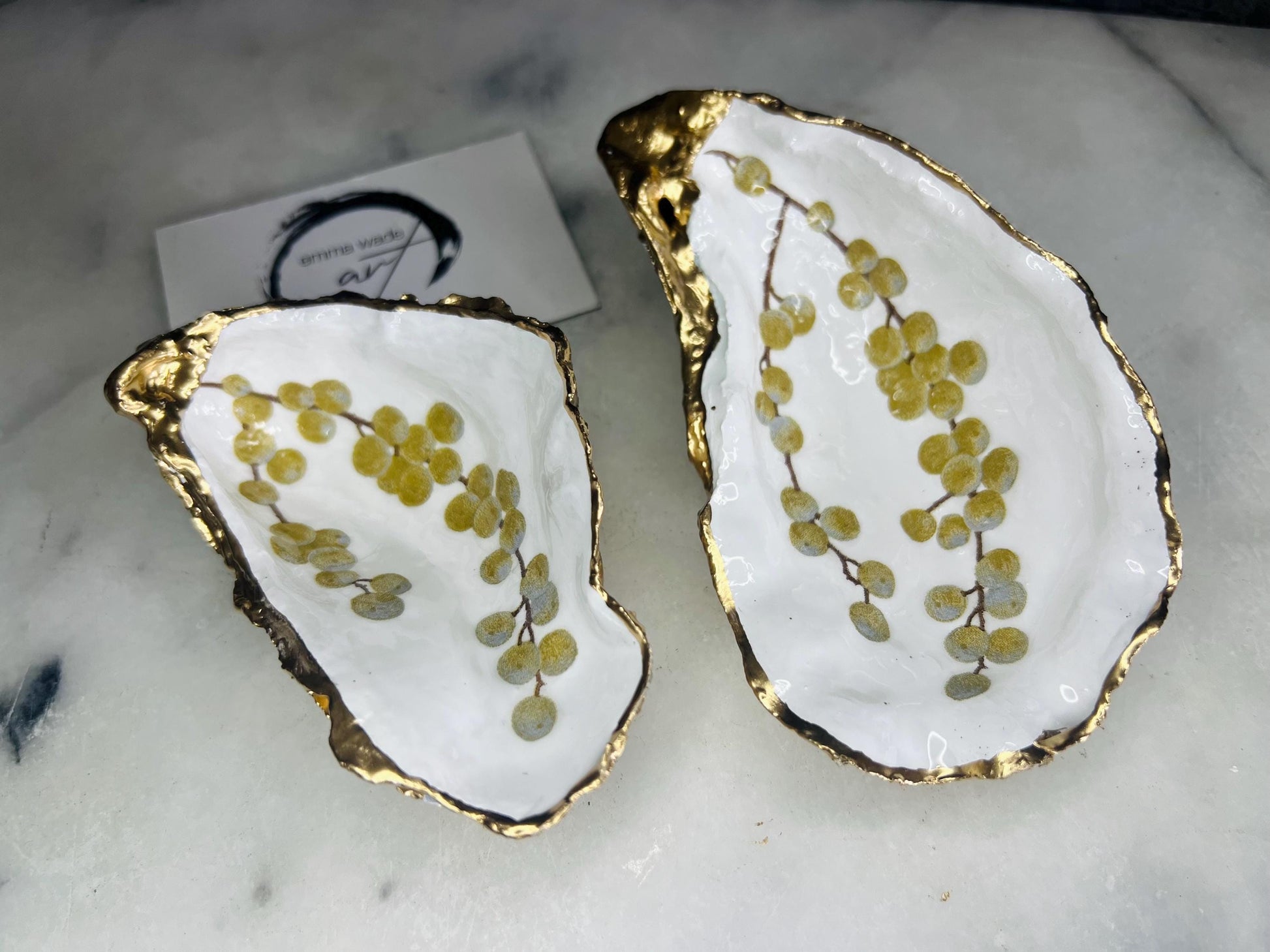 Handmade Dorset oyster shell dish with a gold and white berries design, gilded with liquid gold leaf on the rim and back, and sealed in crystal-clear resin for a glossy shine. Each oyster shell jewellery dish is unique, perfect as a ring holder, trinket tray, or organiser for earrings, cufflinks, and small keepsakes. A meaningful handmade oyster ring dish for weddings, anniversaries, birthdays, bridesmaids, or festive celebrations. Ideal as UK coastal-inspired home décor.