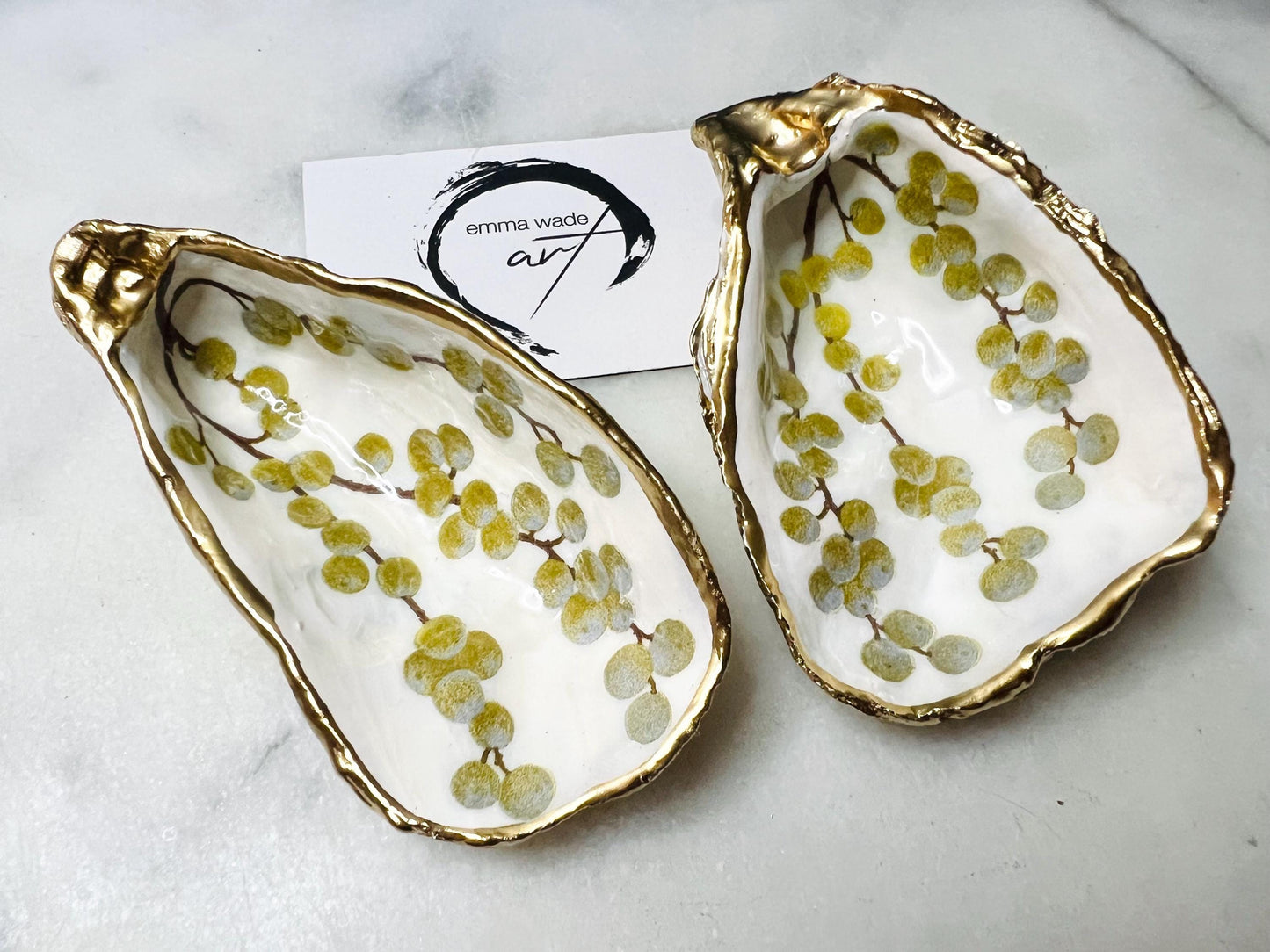 Handmade Dorset oyster shell dish with a gold and white berries design, gilded with liquid gold leaf on the rim and back, and sealed in crystal-clear resin for a glossy shine. Each oyster shell jewellery dish is unique, perfect as a ring holder, trinket tray, or organiser for earrings, cufflinks, and small keepsakes. A meaningful handmade oyster ring dish for weddings, anniversaries, birthdays, bridesmaids, or festive celebrations. Ideal as UK coastal-inspired home décor.