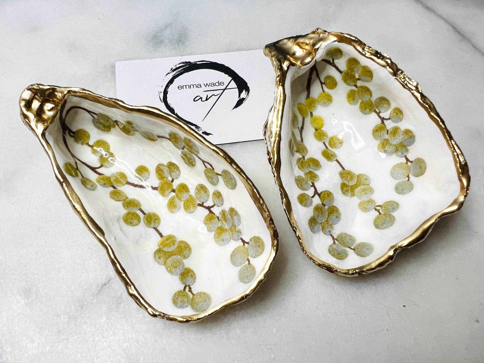 Handmade Dorset oyster shell dish with a gold and white berries design, gilded with liquid gold leaf on the rim and back, and sealed in crystal-clear resin for a glossy shine. Each oyster shell jewellery dish is unique, perfect as a ring holder, trinket tray, or organiser for earrings, cufflinks, and small keepsakes. A meaningful handmade oyster ring dish for weddings, anniversaries, birthdays, bridesmaids, or festive celebrations. Ideal as UK coastal-inspired home décor.