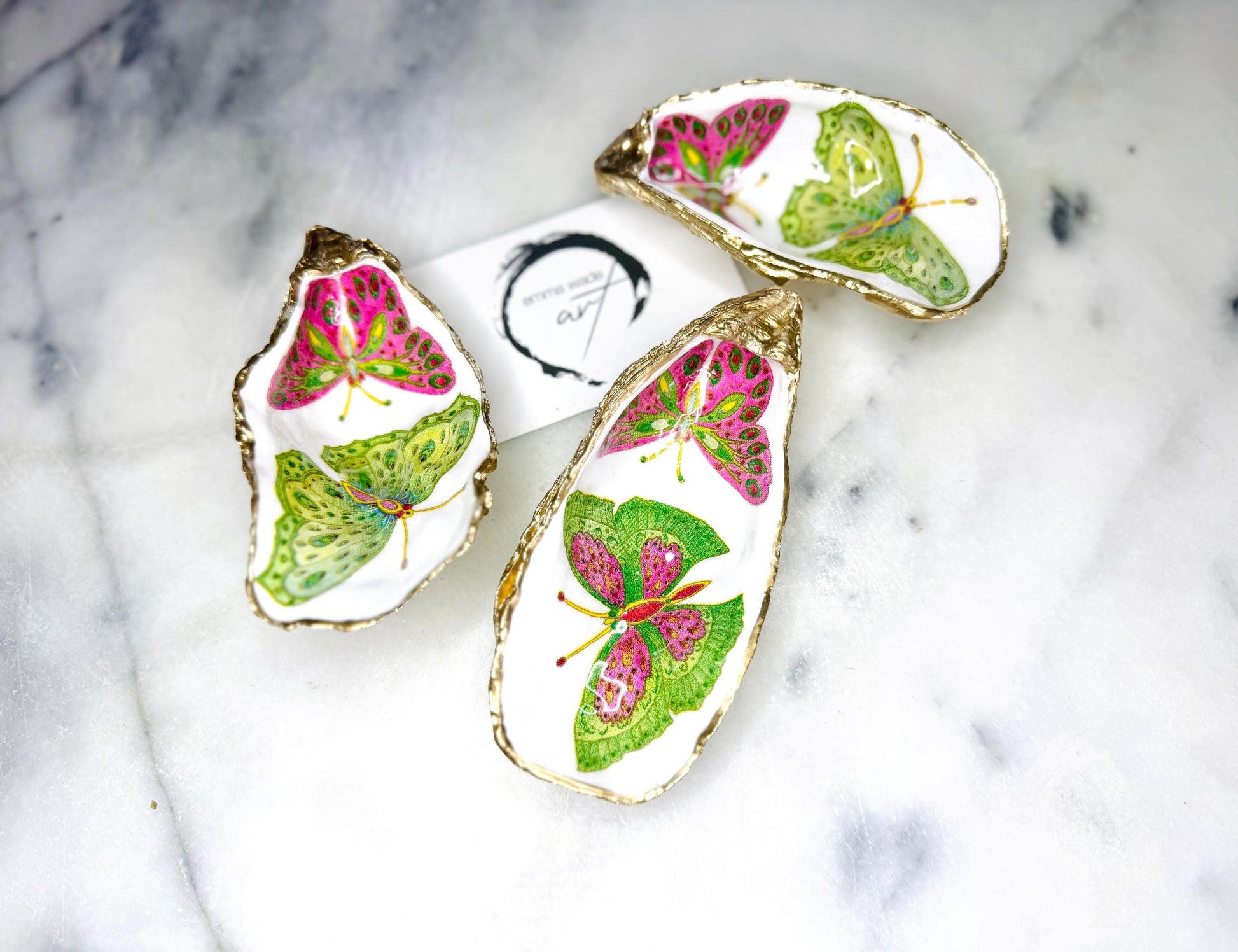 Handmade butterfly oyster shell trinket dish with colourful blue green and pink butterfly designs, edged and backed in gold leaf, Dorset coastal shell jewellery holder with glossy resin finish, luxury ring dish, coastal home decor gift, unique handmade shell dish for jewellery storage, beach house accessory, UK artisan oyster shell dish