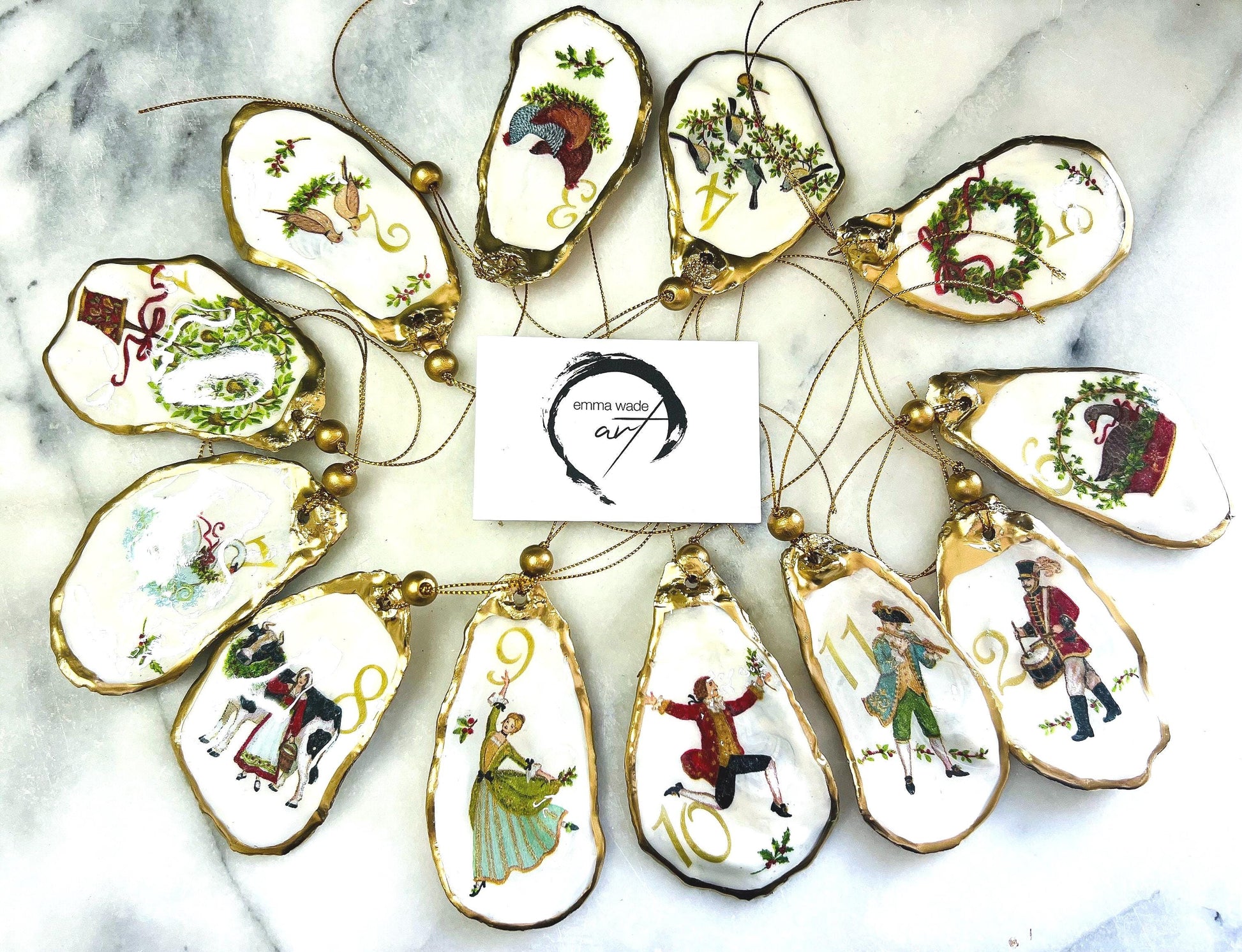 Handmade Twelve Days of Christmas oyster shell ornament set featuring all twelve traditional carol illustrations, finished with gold leaf edging, glossy resin and gold hanging cords. Coastal heirloom Christmas decorations handcrafted from Dorset oyster shells.