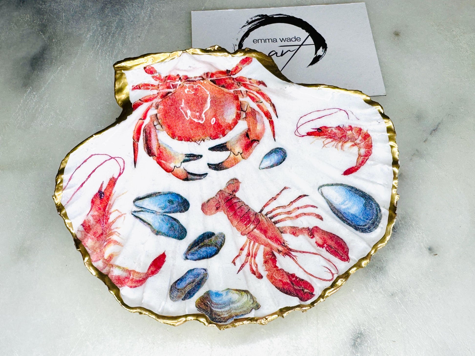 Handmade Dorset scallop shell trinket dish featuring a vibrant red crab and lobster coastal design, hand-gilded with real liquid gold leaf and sealed in crystal-clear glossy resin. Nautical shell jewellery dish inspired by the Dorset coastline, perfect as a ring holder, coastal home décor accent, seaside gift, or luxury beach house accessory.