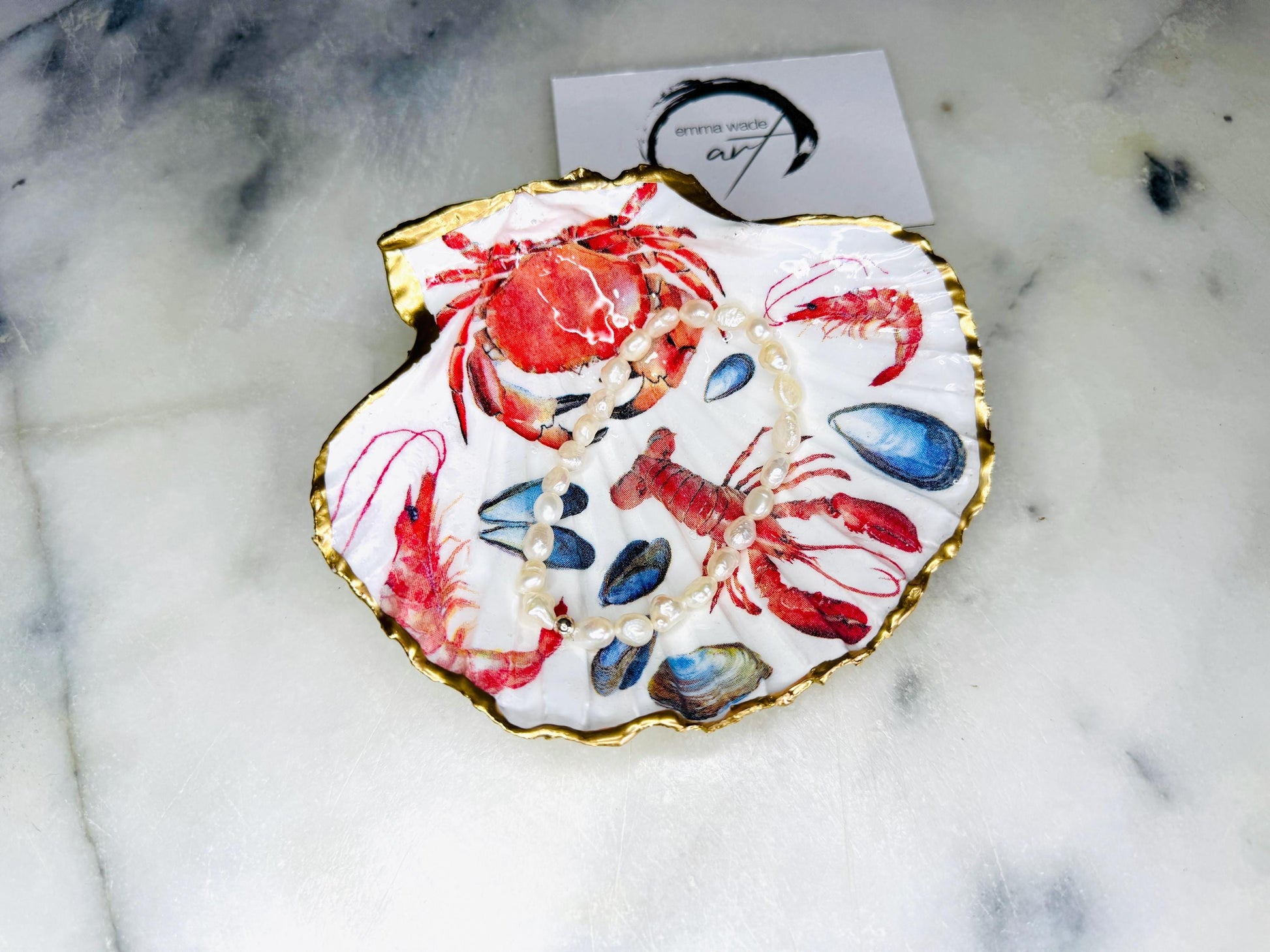 Handmade Dorset scallop shell trinket dish featuring a vibrant red crab and lobster coastal design, hand-gilded with real liquid gold leaf and sealed in crystal-clear glossy resin. Nautical shell jewellery dish inspired by the Dorset coastline, perfect as a ring holder, coastal home décor accent, seaside gift, or luxury beach house accessory.