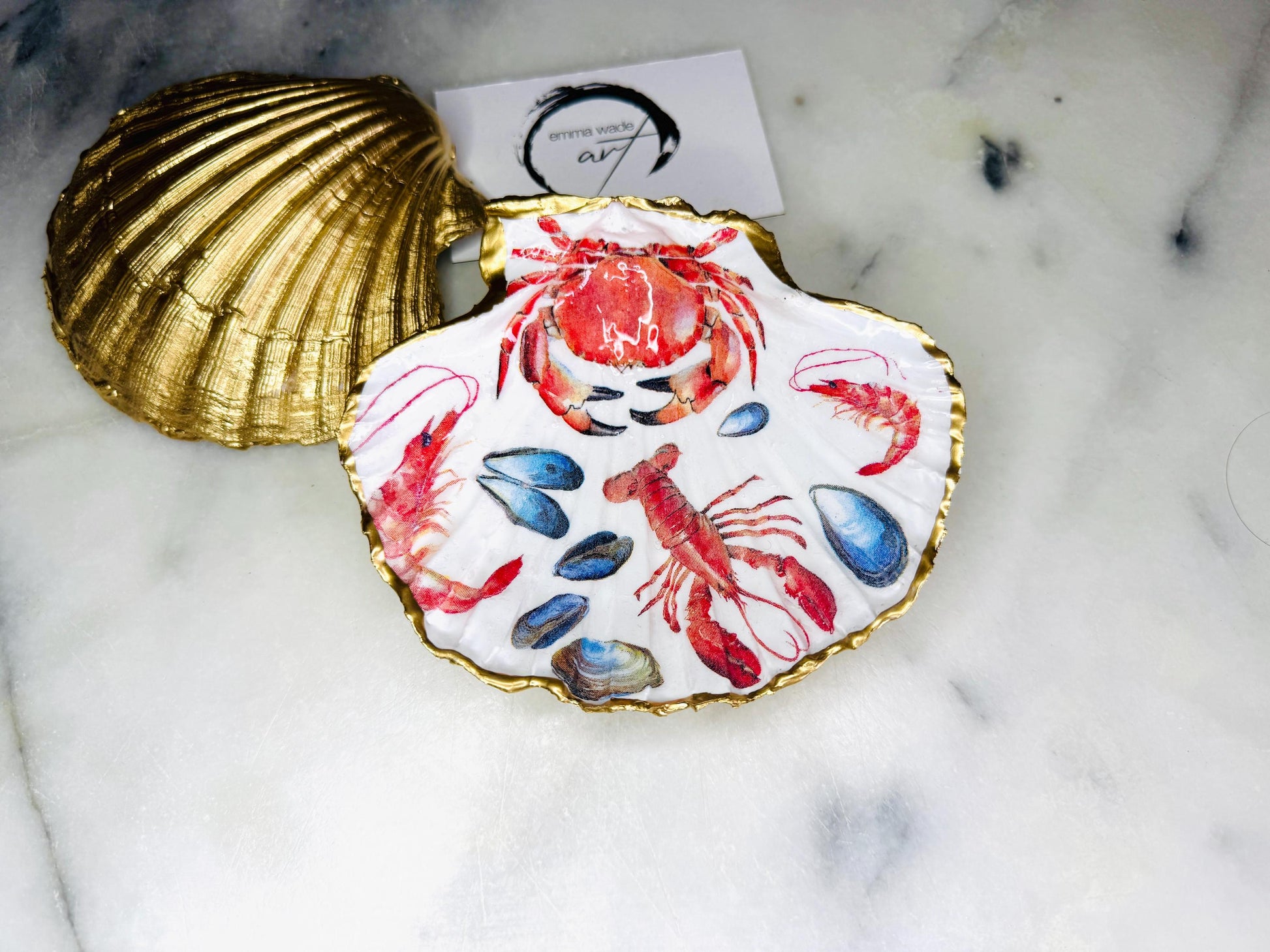 Handmade Dorset scallop shell trinket dish featuring a vibrant red crab and lobster coastal design, hand-gilded with real liquid gold leaf and sealed in crystal-clear glossy resin. Nautical shell jewellery dish inspired by the Dorset coastline, perfect as a ring holder, coastal home décor accent, seaside gift, or luxury beach house accessory.