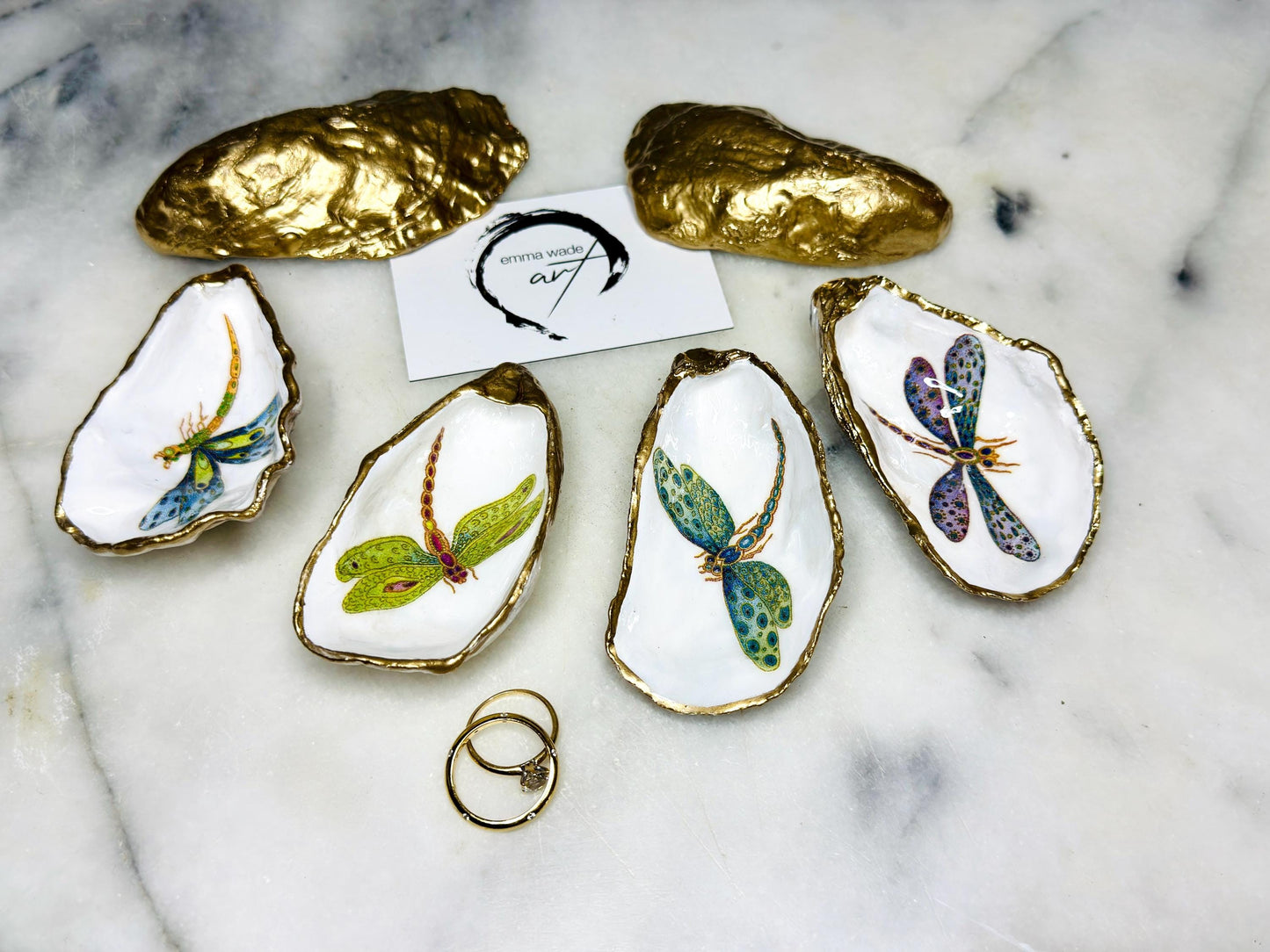 Handmade dragonfly oyster shell trinket dish with hand-gilded gold leaf edges and glossy resin finish, created from sustainably sourced Dorset shells. Unique coastal jewellery holder and ring dish, ideal as a vanity tray, trinket tray or decorative keepsake. Nature inspired home decor gift for birthdays, weddings, anniversaries, housewarmings and Mother’s Day. One of a kind artisan shell dish, beautifully presented in a gift box.