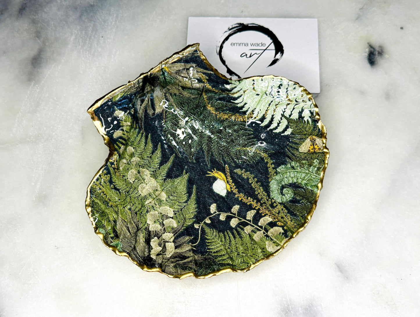 Handmade fern green scallop shell trinket dish with botanical forest fern design, gold leaf edging, and glossy resin finish. Natural Dorset shell jewellery dish inspired by woodland décor and cottagecore interiors, styled as a ring holder, trinket tray, or coastal nature-inspired gift.
