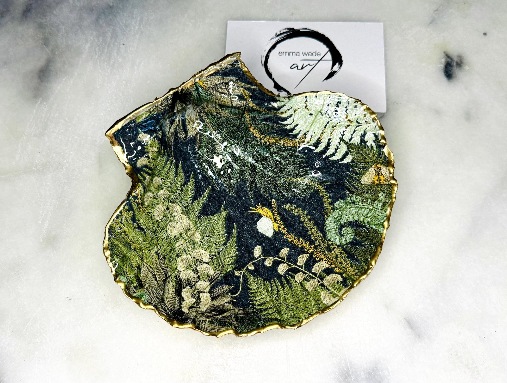 Handmade fern green scallop shell trinket dish with botanical forest fern design, gold leaf edging, and glossy resin finish. Natural Dorset shell jewellery dish inspired by woodland décor and cottagecore interiors, styled as a ring holder, trinket tray, or coastal nature-inspired gift.