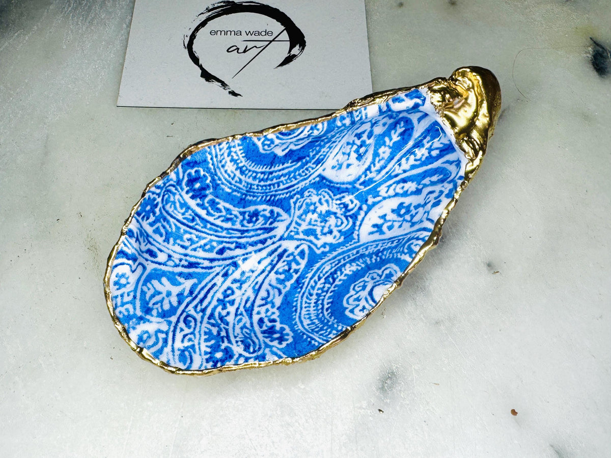 Blue and white paisley oyster shell salt cellar set with gold leaf edging and matching gold crystal spoons. Handmade Dorset oyster shell pinch pots finished in glossy food safe resin. Coastal dining decor and luxury beach house table accessory.