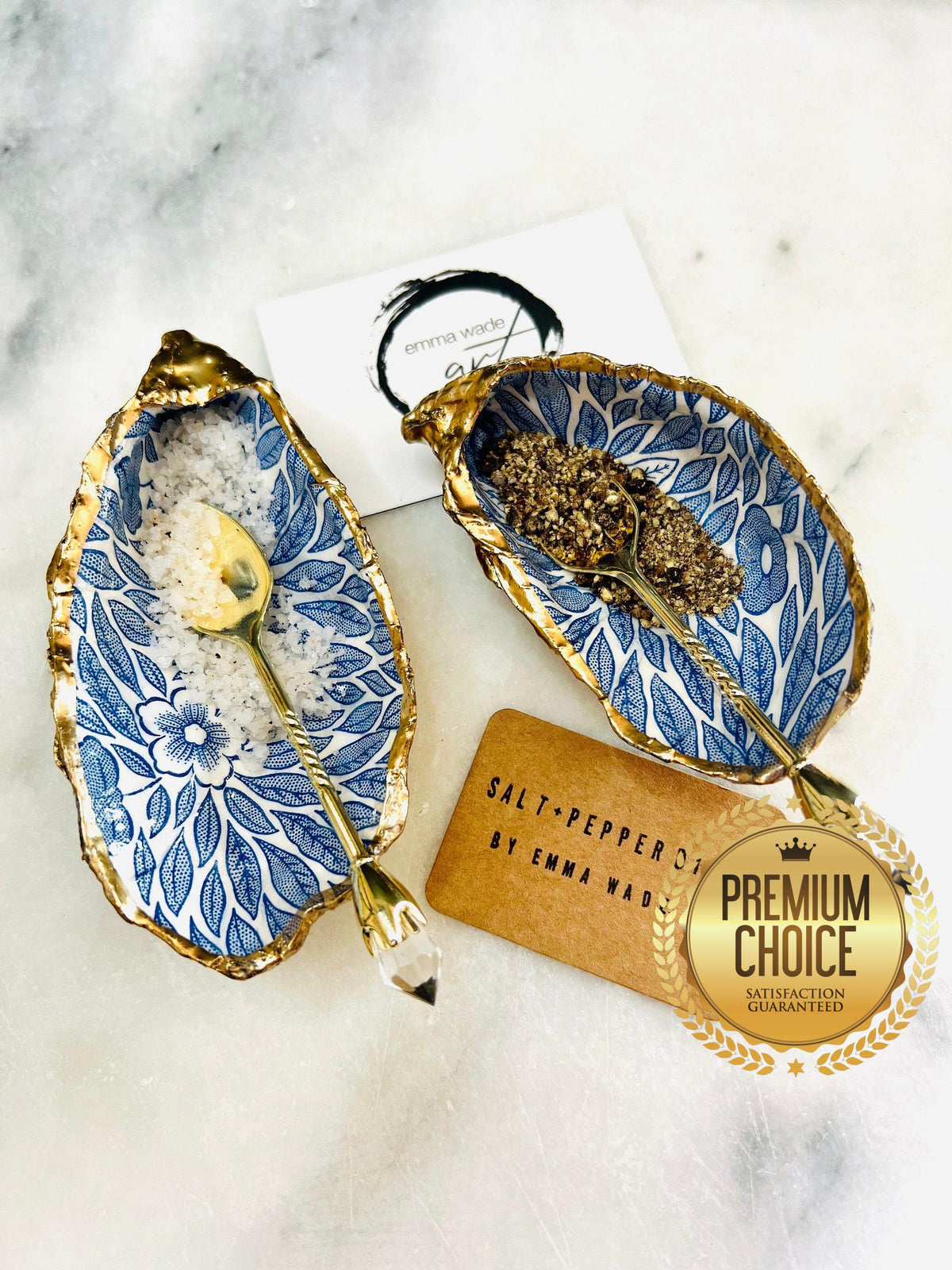 Sustainable Dorset oyster shell cruet set featuring blue floral designs and real gold leaf edges | Handmade salt and pepper pinch pots, sealed with food-safe glossy resin and presented in a sustainable kraft gift box | A unique salt gift for weddings, anniversaries, and coastal dining | Includes optional gold crystal spoons | Perfect handmade gift for beach house decor or ocean-inspired table styling