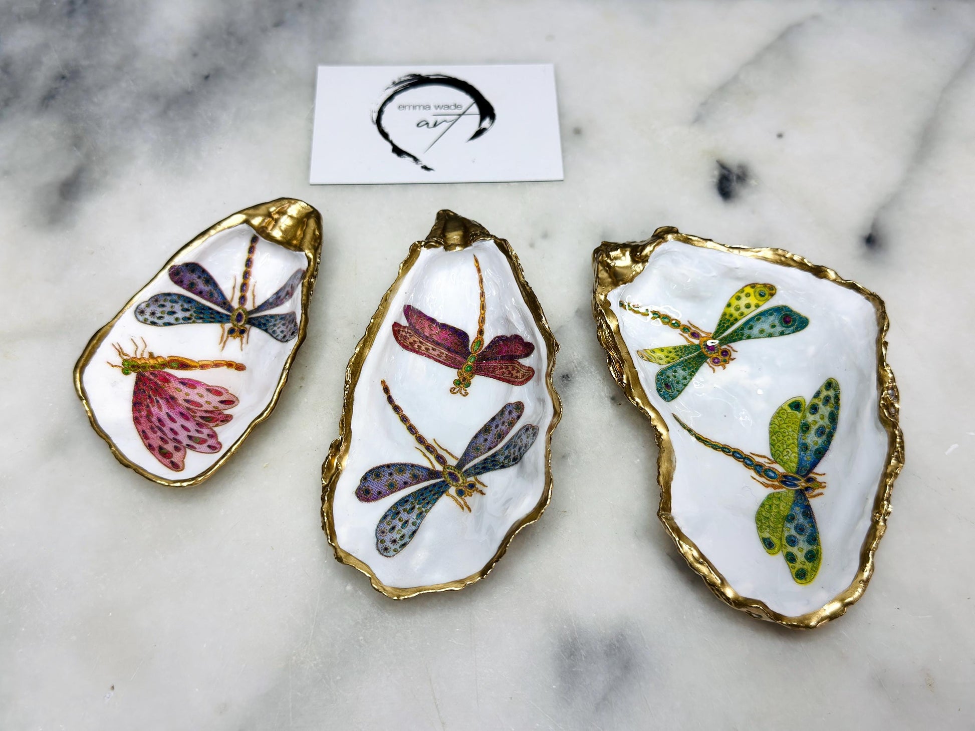 Handmade dragonfly oyster shell trinket dish with hand-gilded gold leaf edges and glossy resin finish, created from sustainably sourced Dorset shells. Unique coastal jewellery holder and ring dish, ideal as a vanity tray, trinket tray or decorative keepsake. Nature inspired home decor gift for birthdays, weddings, anniversaries, housewarmings and Mother’s Day. One of a kind artisan shell dish, beautifully presented in a gift box.