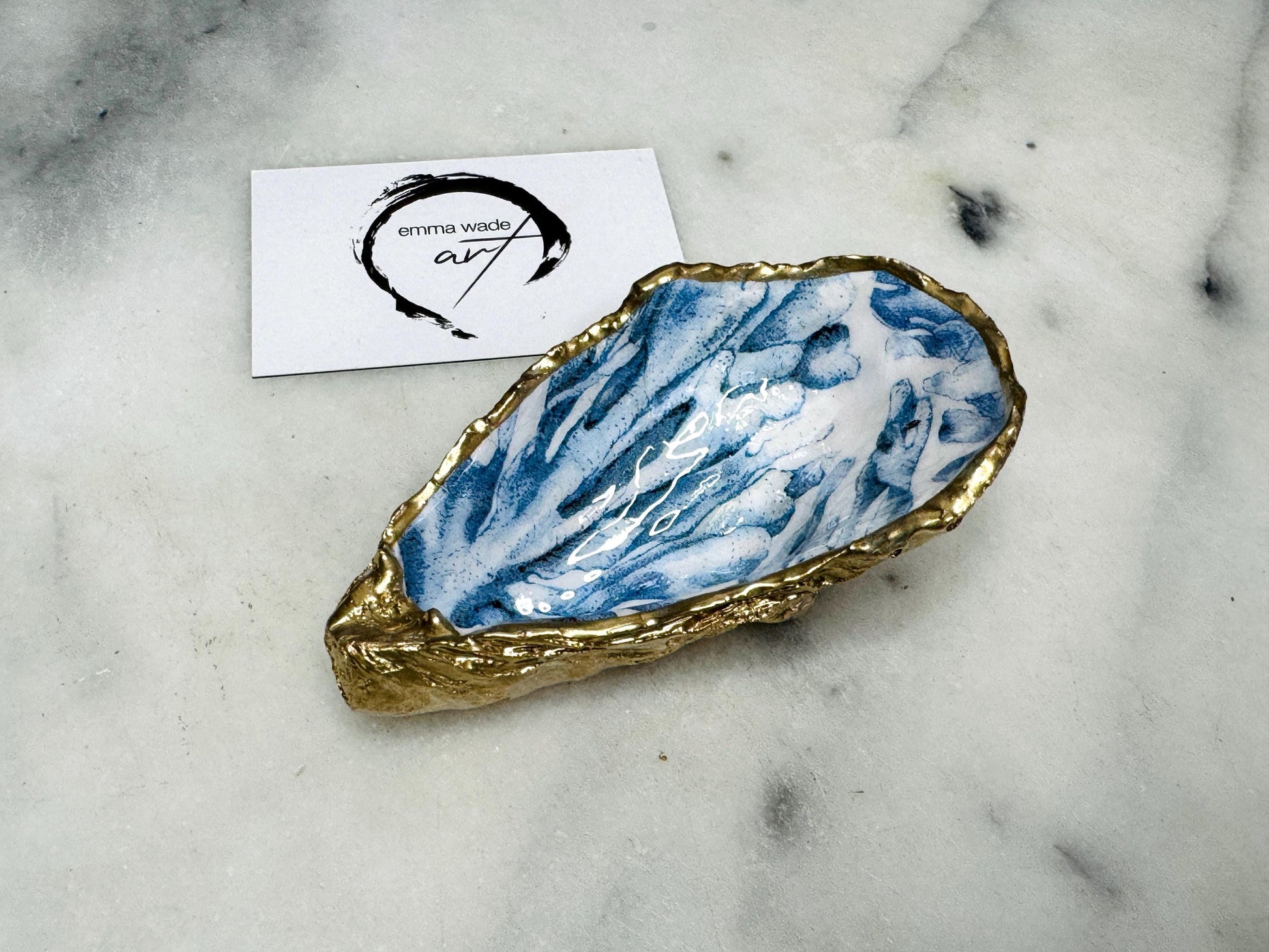 Handcrafted Dorset oyster shell trinket dish featuring blue seaweed design | Gilded with liquid gold leaf and sealed with clear resin | Perfect as a jewellery dish, ring holder, or decorative coastal ornament | Optional gold antler stand available | Each shell is sustainably sourced and hand finished with unique natural variations | Ideal ocean-inspired gift for weddings, anniversaries, birthdays, or home decor