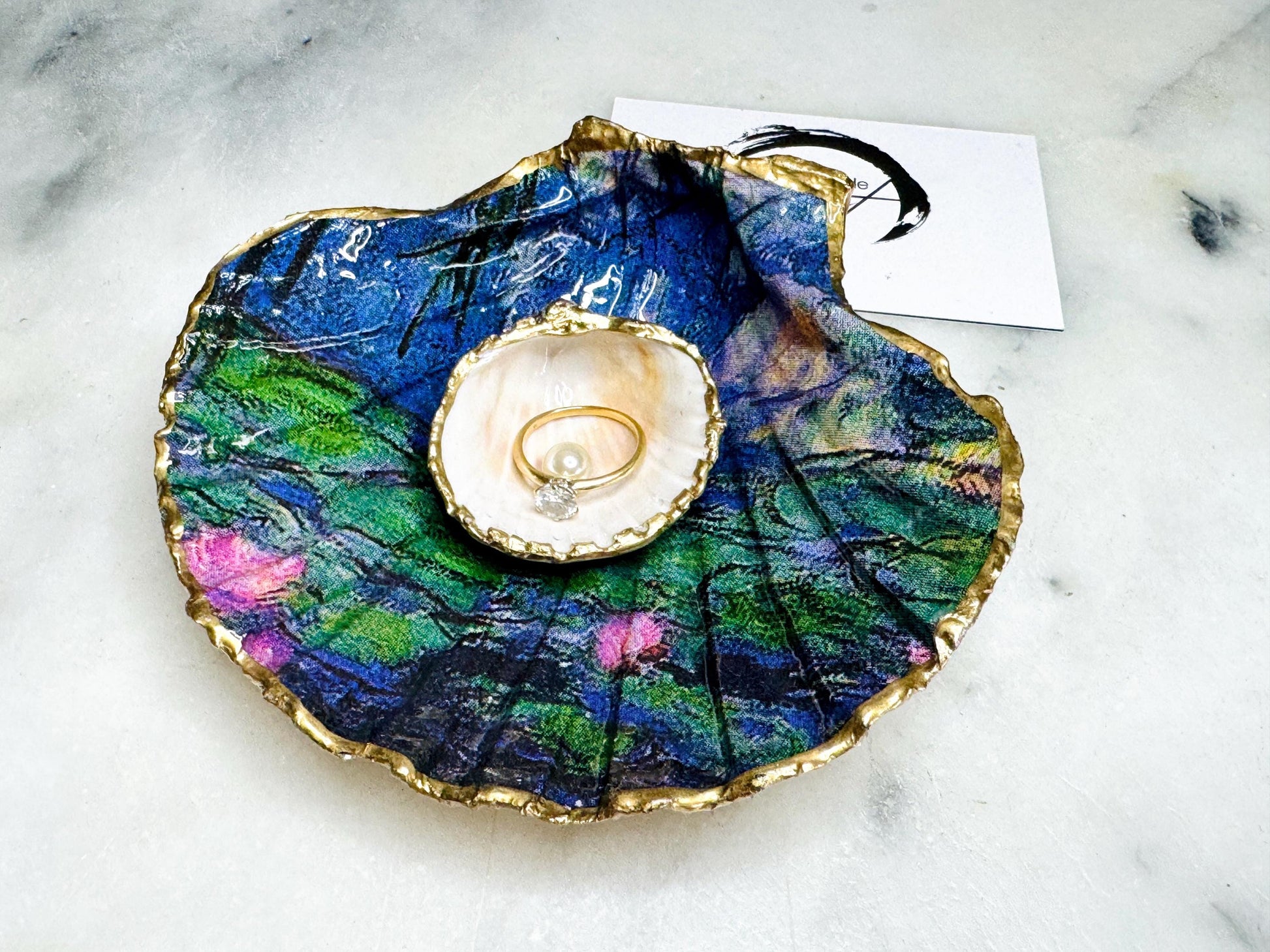 Claude Monet Waterlilies inspired shell dish set featuring a scallop trinket dish and cockle ring holder | Decorated with blue and pink floral waterlilies | Gilded with real gold leaf and sealed in high gloss resin | Perfect as a wedding ring tray, jewellery dish, or vanity display | Handmade in Dorset from sustainably sourced shells | A coastal art-inspired gift for weddings, birthdays, or anniversaries