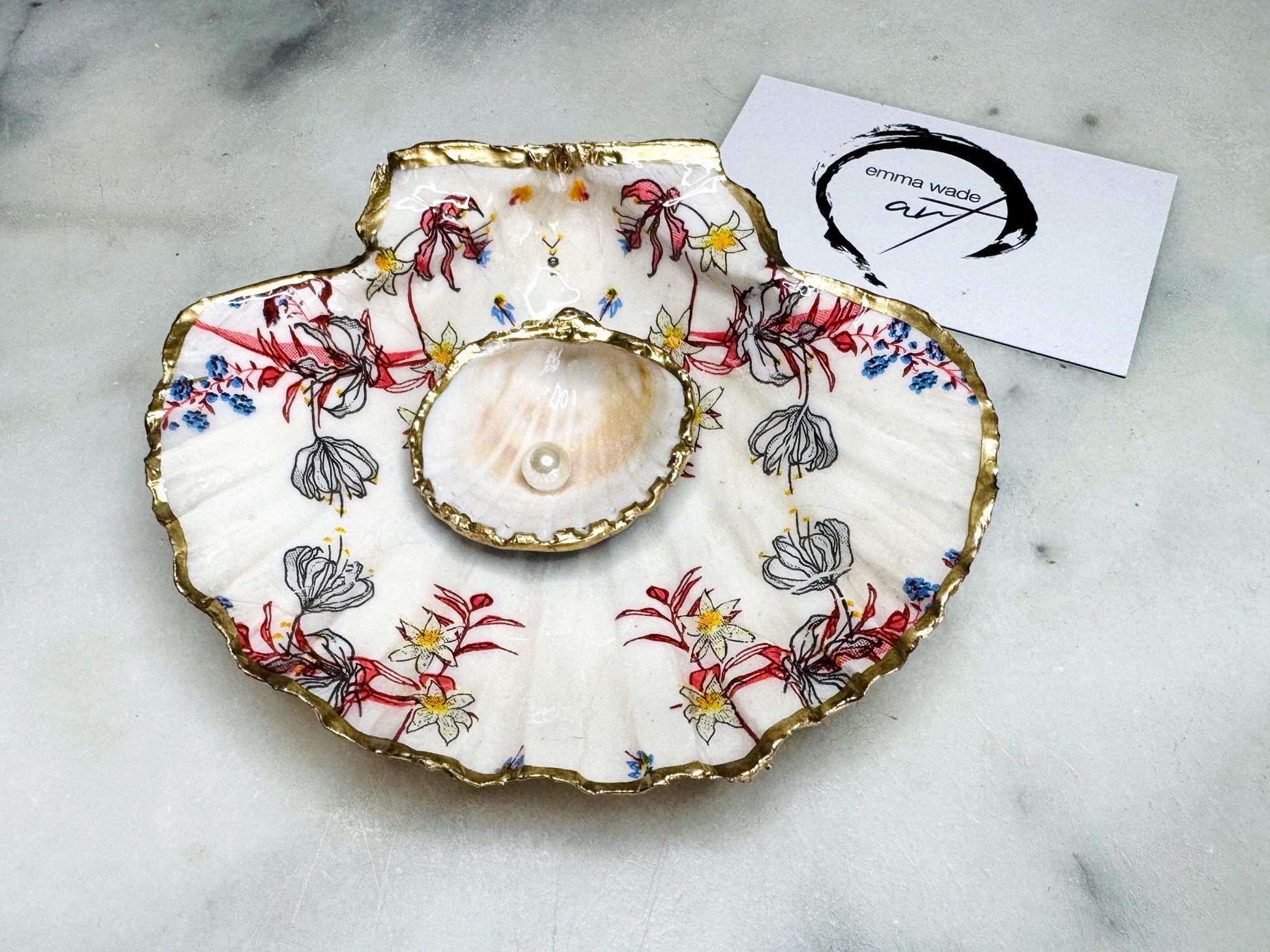 Handcrafted Dorset shell dish set featuring red and blue floral designs on scallop and cockle shells | Cockle shell includes a Swarovski pearl ring rest to prevent rings from sliding | Gilded with liquid gold leaf and sealed with glossy resin | Perfect as a jewellery or ring holder, trinket tray, or coastal gift | Each shell is sustainably sourced and hand finished in the UK | Ideal wedding or anniversary keepsake