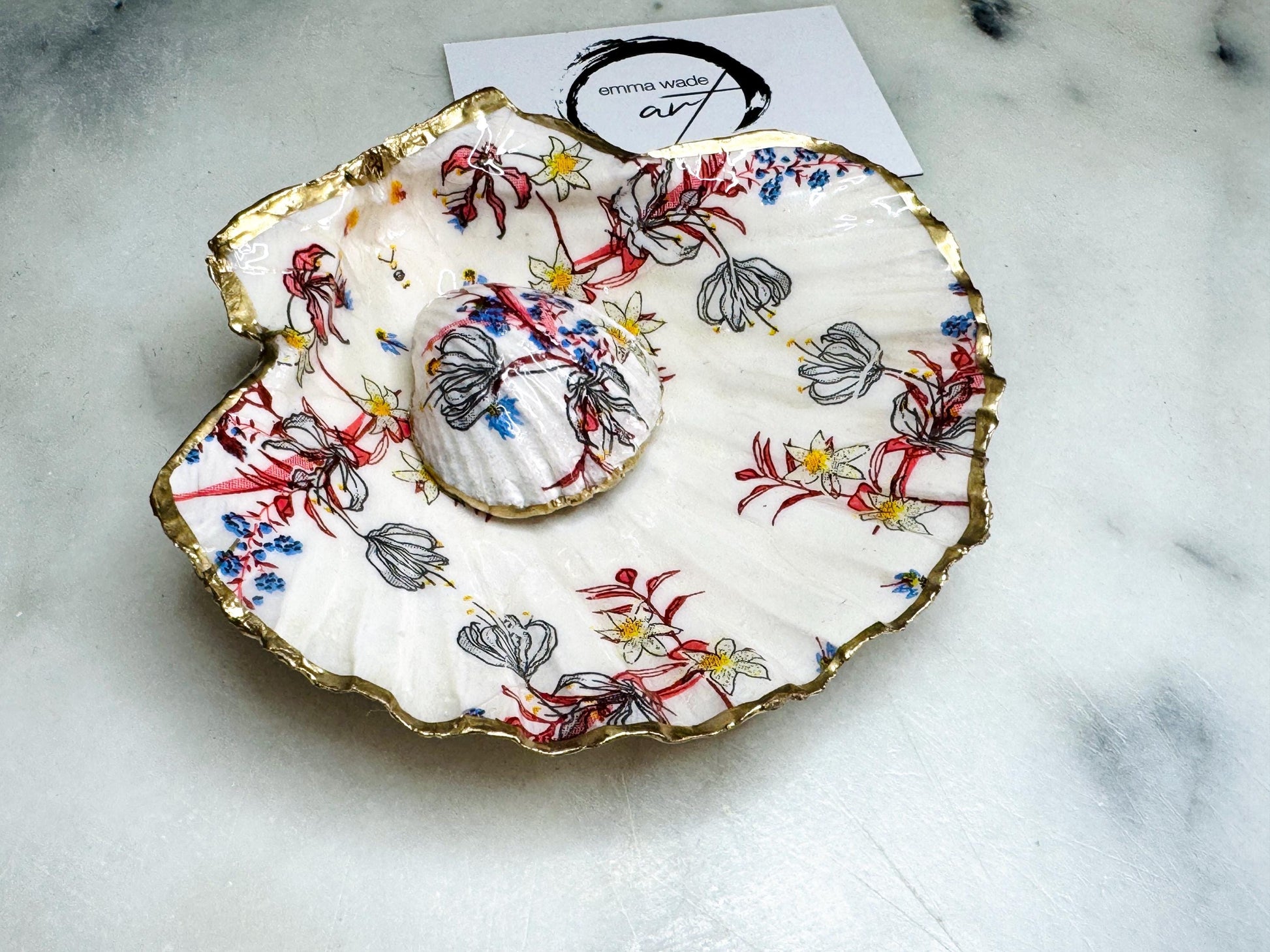 Handcrafted Dorset shell dish set featuring red and blue floral designs on scallop and cockle shells | Cockle shell includes a Swarovski pearl ring rest to prevent rings from sliding | Gilded with liquid gold leaf and sealed with glossy resin | Perfect as a jewellery or ring holder, trinket tray, or coastal gift | Each shell is sustainably sourced and hand finished in the UK | Ideal wedding or anniversary keepsake