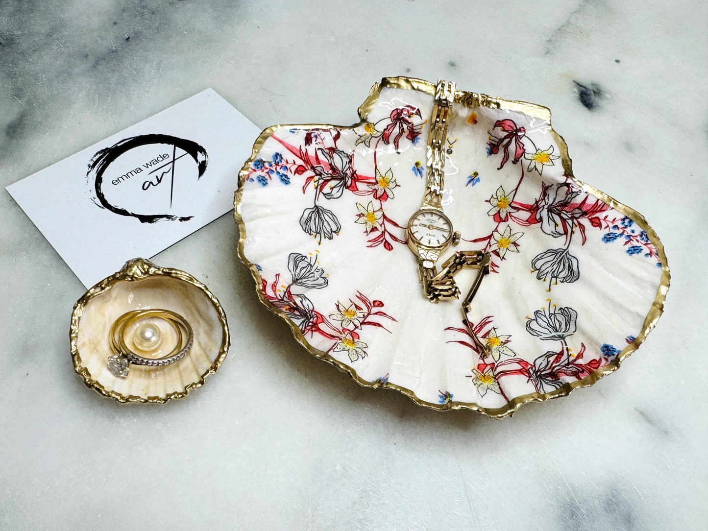 Handcrafted Dorset shell dish set featuring red and blue floral designs on scallop and cockle shells | Cockle shell includes a Swarovski pearl ring rest to prevent rings from sliding | Gilded with liquid gold leaf and sealed with glossy resin | Perfect as a jewellery or ring holder, trinket tray, or coastal gift | Each shell is sustainably sourced and hand finished in the UK | Ideal wedding or anniversary keepsake