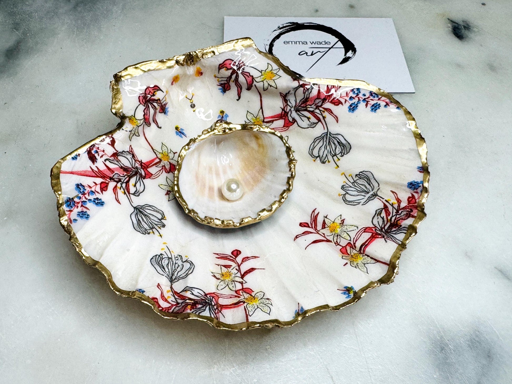 Handcrafted Dorset shell dish set featuring red and blue floral designs on scallop and cockle shells | Cockle shell includes a Swarovski pearl ring rest to prevent rings from sliding | Gilded with liquid gold leaf and sealed with glossy resin | Perfect as a jewellery or ring holder, trinket tray, or coastal gift | Each shell is sustainably sourced and hand finished in the UK | Ideal wedding or anniversary keepsake