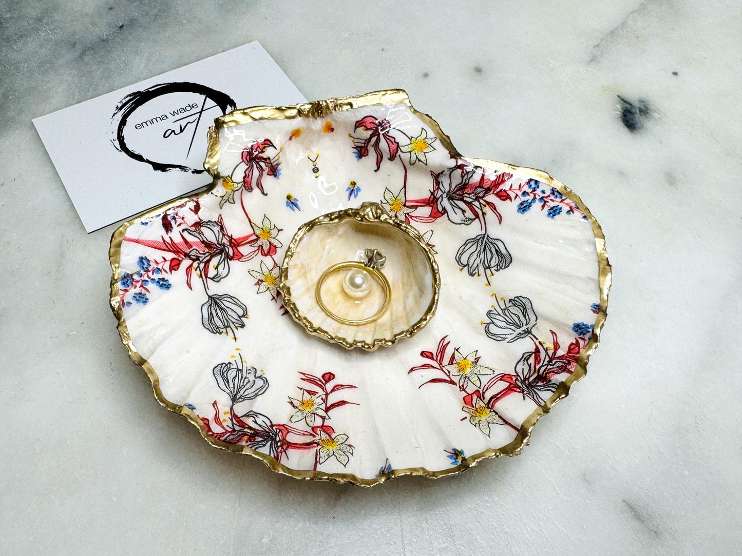 Handcrafted Dorset shell dish set featuring red and blue floral designs on scallop and cockle shells | Cockle shell includes a Swarovski pearl ring rest to prevent rings from sliding | Gilded with liquid gold leaf and sealed with glossy resin | Perfect as a jewellery or ring holder, trinket tray, or coastal gift | Each shell is sustainably sourced and hand finished in the UK | Ideal wedding or anniversary keepsake