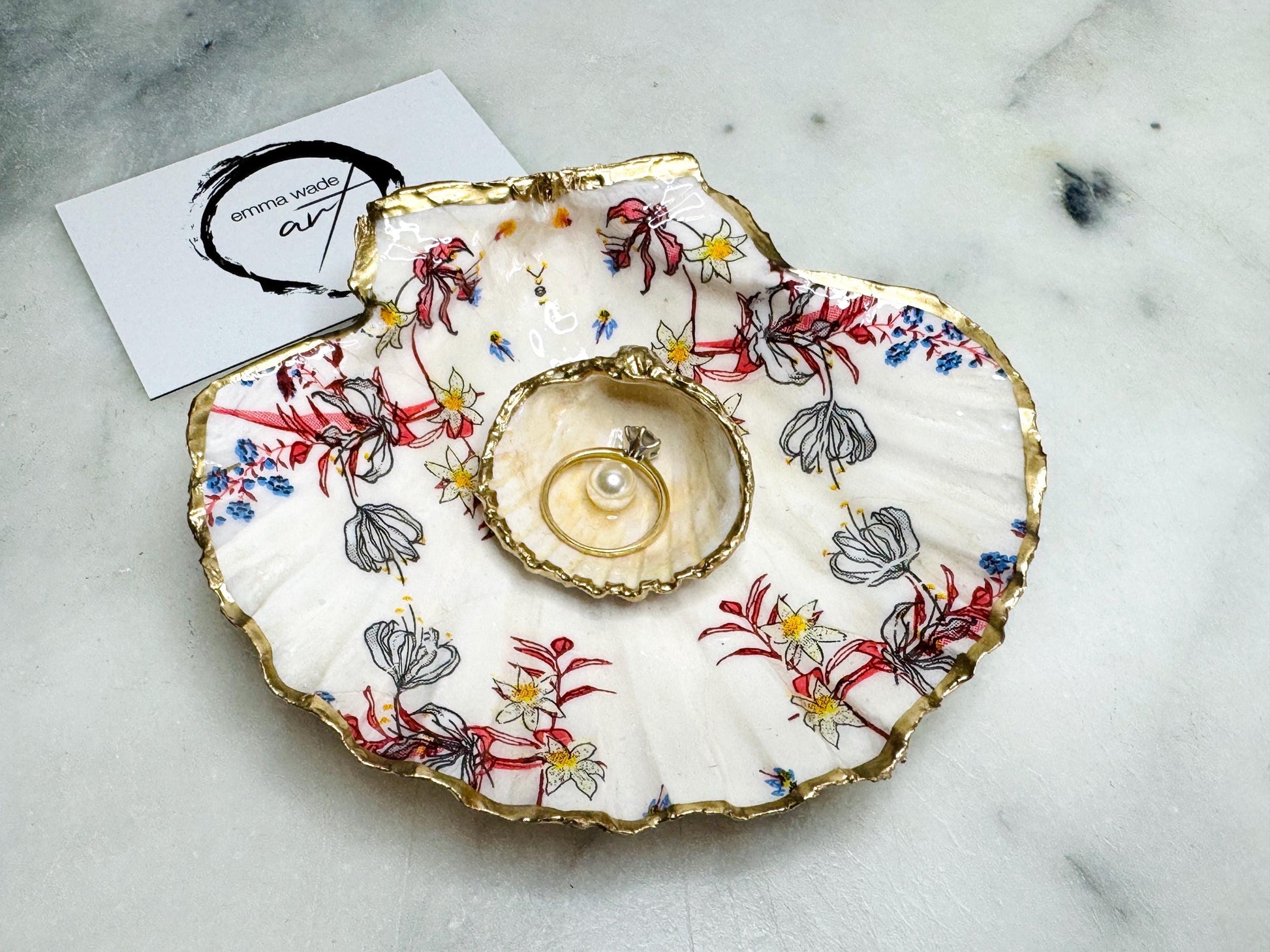 Handcrafted Dorset shell dish set featuring red and blue floral designs on scallop and cockle shells | Cockle shell includes a Swarovski pearl ring rest to prevent rings from sliding | Gilded with liquid gold leaf and sealed with glossy resin | Perfect as a jewellery or ring holder, trinket tray, or coastal gift | Each shell is sustainably sourced and hand finished in the UK | Ideal wedding or anniversary keepsake