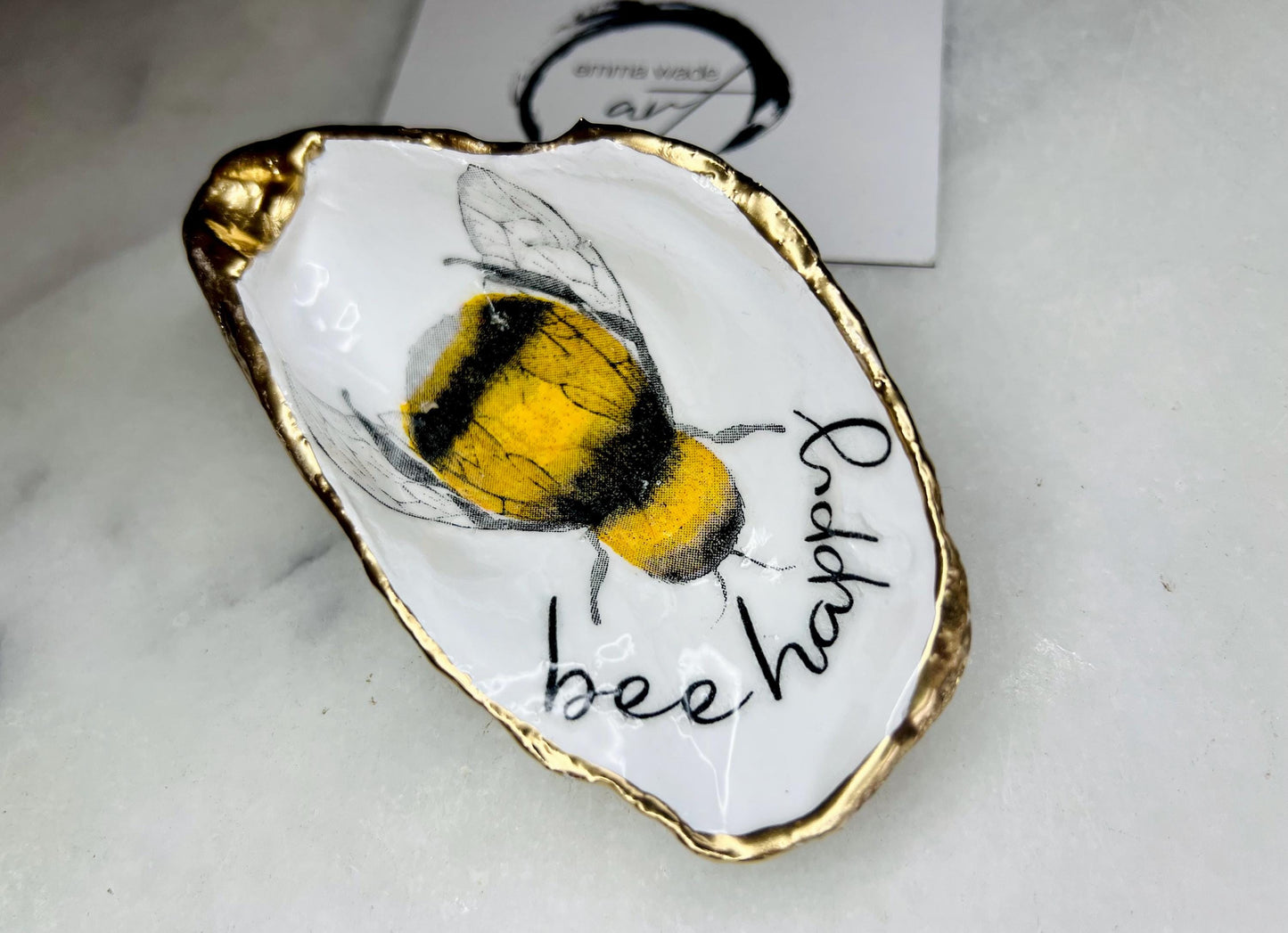 bee happy oyster shell trinket dish, Dorset oyster shell jewellery holder, handmade bee design coastal decor, gold leaf gilded oyster shell ornament, sustainable oyster shell dish UK, bumble bee oyster shell jewellery tray, nature inspired bee oyster shell gift, eco friendly oyster shell bathroom accessory, oyster shell salt and pepper pinch pot, unique bee themed oyster shell keepsake, handmade Dorset oyster shell decor, bee lover jewellery dish gift, coastal oyster shell art UK