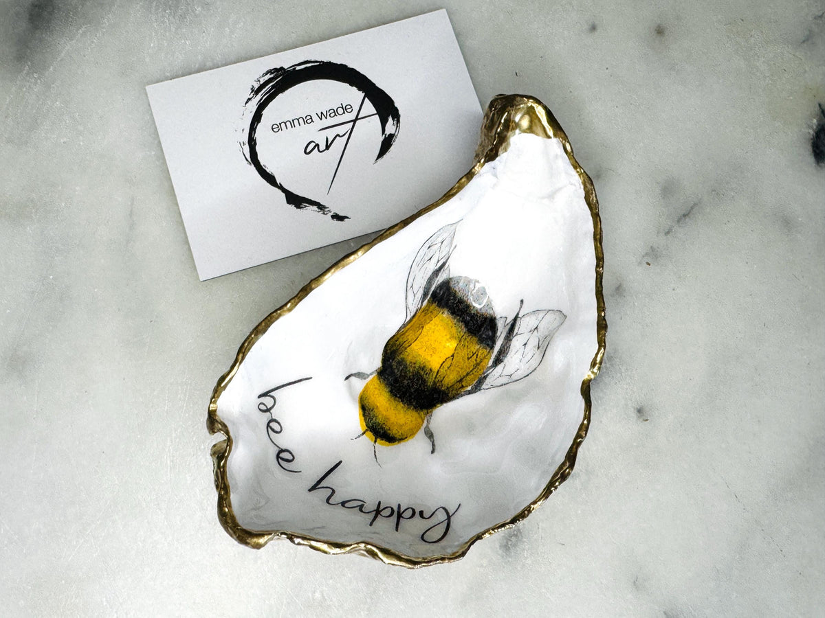 bee happy oyster shell trinket dish, Dorset oyster shell jewellery holder, handmade bee design coastal decor, gold leaf gilded oyster shell ornament, sustainable oyster shell dish UK, bumble bee oyster shell jewellery tray, nature inspired bee oyster shell gift, eco friendly oyster shell bathroom accessory, oyster shell salt and pepper pinch pot, unique bee themed oyster shell keepsake, handmade Dorset oyster shell decor, bee lover jewellery dish gift, coastal oyster shell art UK