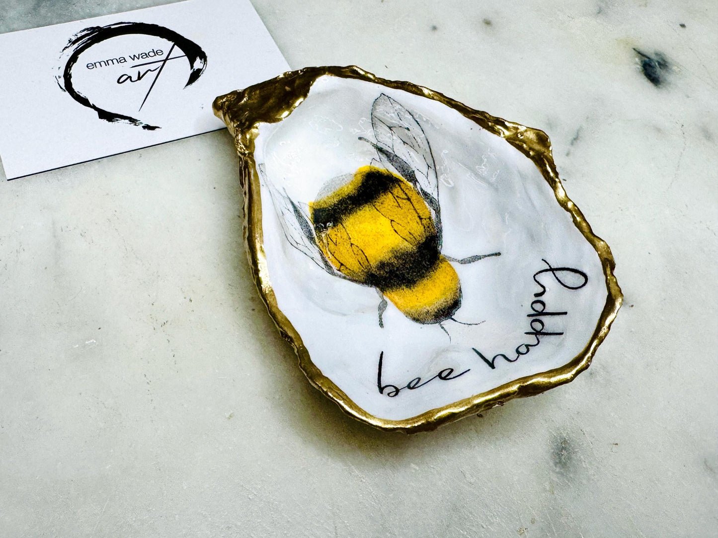 bee happy oyster shell trinket dish, Dorset oyster shell jewellery holder, handmade bee design coastal decor, gold leaf gilded oyster shell ornament, sustainable oyster shell dish UK, bumble bee oyster shell jewellery tray, nature inspired bee oyster shell gift, eco friendly oyster shell bathroom accessory, oyster shell salt and pepper pinch pot, unique bee themed oyster shell keepsake, handmade Dorset oyster shell decor, bee lover jewellery dish gift, coastal oyster shell art UK