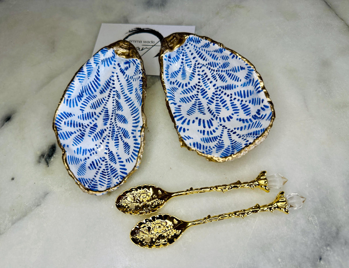 Sustainable Dorset oyster shell cruet set featuring blue floral designs and real gold leaf edges | Handmade salt and pepper pinch pots, sealed with food-safe glossy resin and presented in a sustainable kraft gift box | A unique salt gift for weddings, anniversaries, and coastal dining | Includes optional gold crystal spoons | Perfect handmade gift for beach house decor or ocean-inspired table styling | Maimekko Design